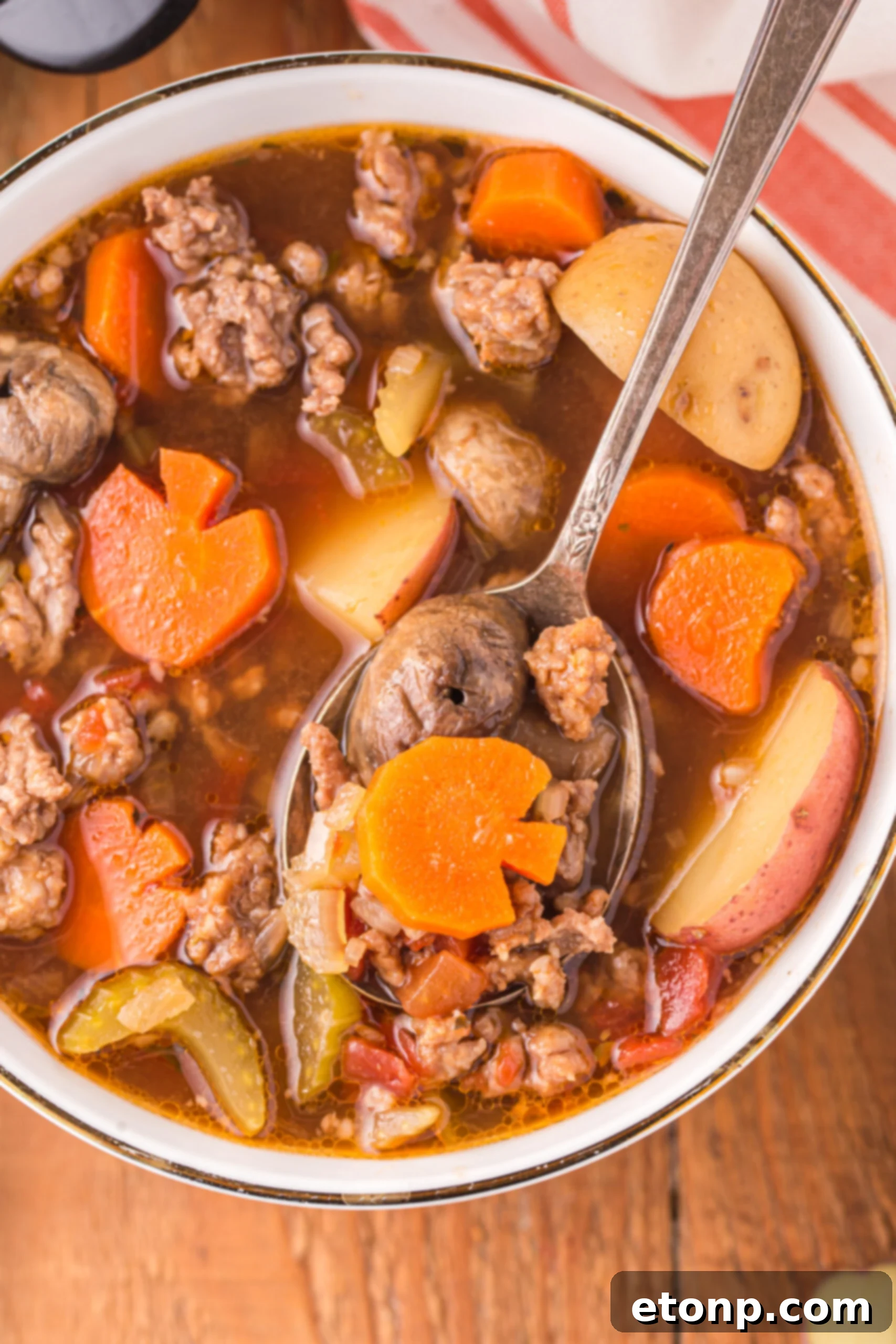 Overhead view of a silver spoon removing a bite of Witches Brew Stew.