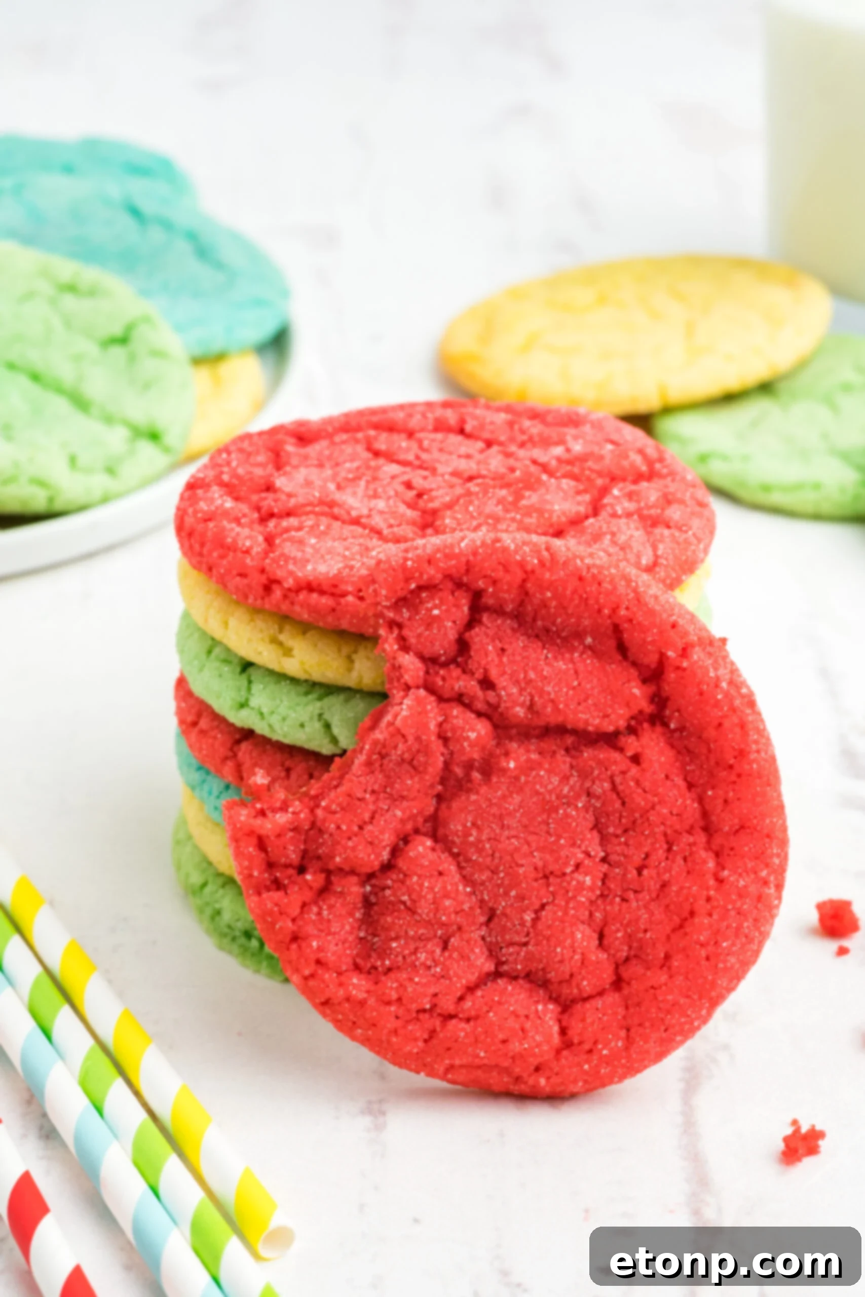 Fruity Gelatin Delights 17 Front view of a Jello Cookie, with a bite removed, propped on a stack of cookies