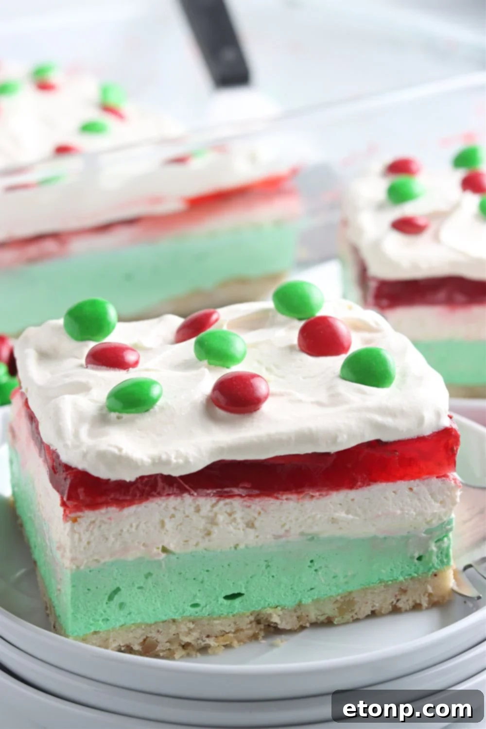 A single plate featuring a generous slice of the Christmas dessert lasagna, showcasing all the vibrant, festive layers.