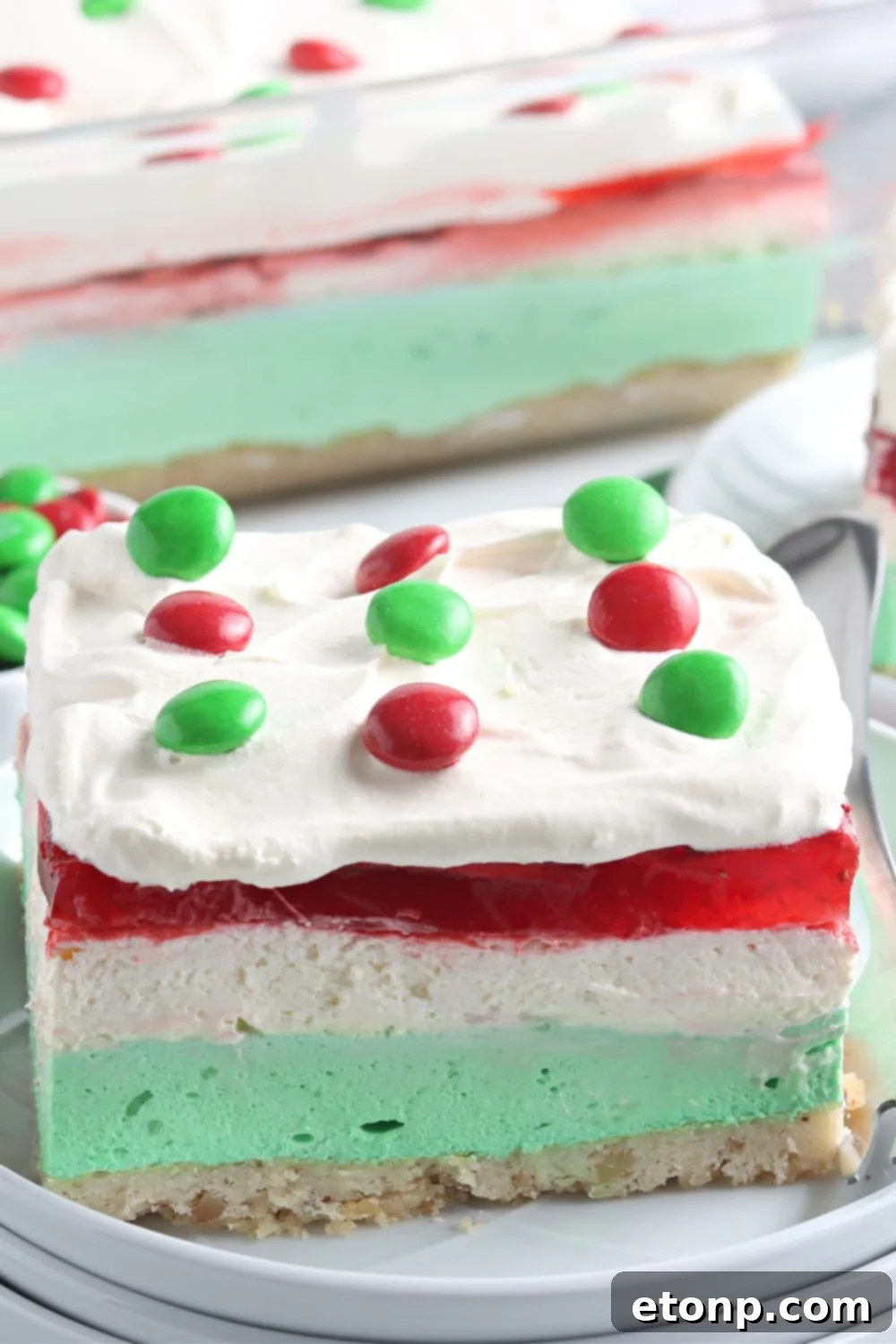 A close-up view of a perfectly portioned slice of Christmas lasagna on a plate, highlighting the distinct and colorful layers of the festive dessert.