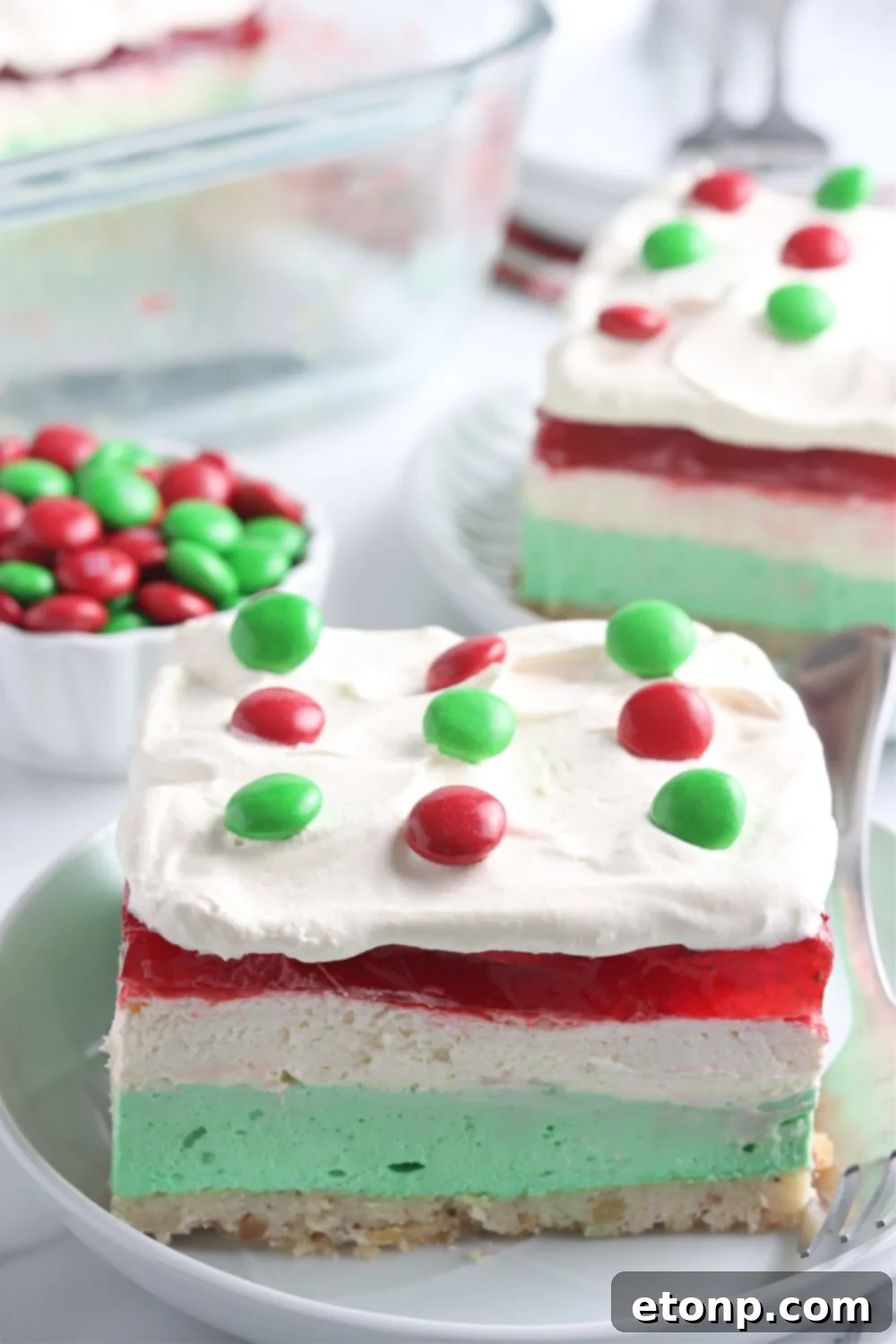 Close-up of the festive No-Bake Christmas Lush, showcasing its distinct, vibrant layers of green, white, and red, ready to be served at a holiday gathering.