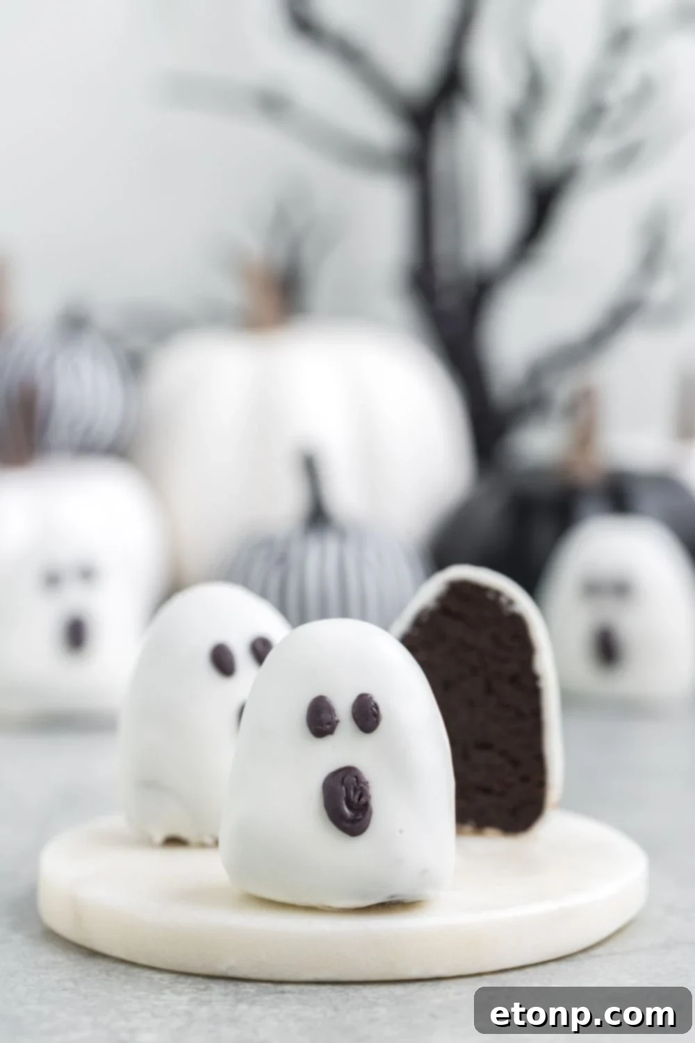 A perfectly sliced truffle displayed on a marble cutting board, with an assortment of additional truffles artfully spread across the table in the background.