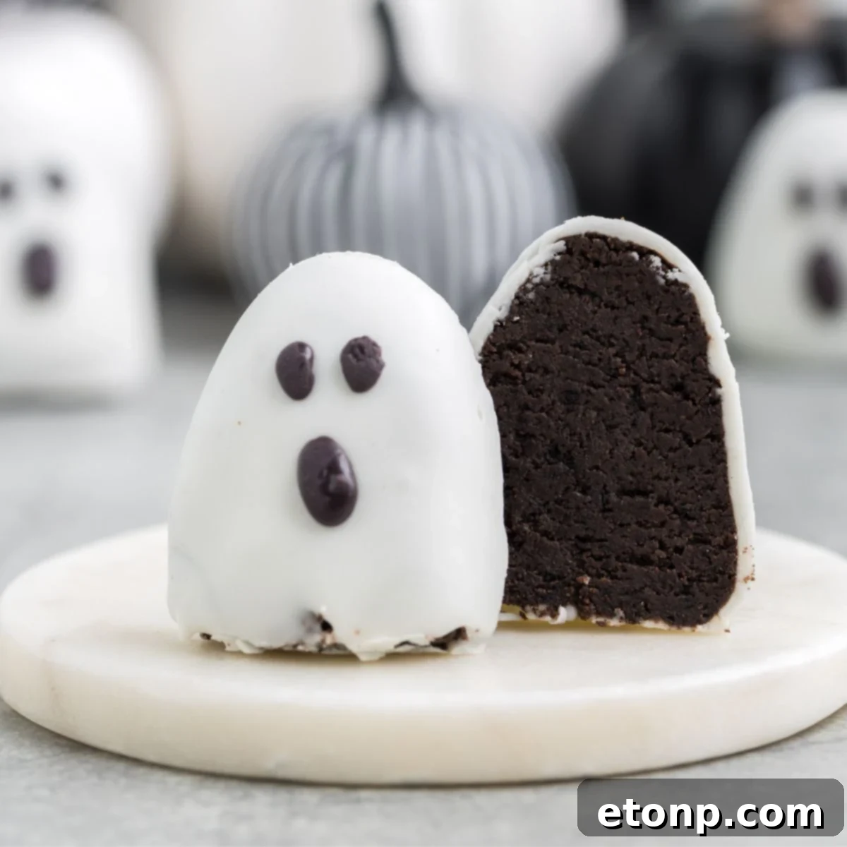 A perfectly sliced Halloween Oreo truffle resting on a elegant marble platter, revealing its rich, dark interior and creamy texture.