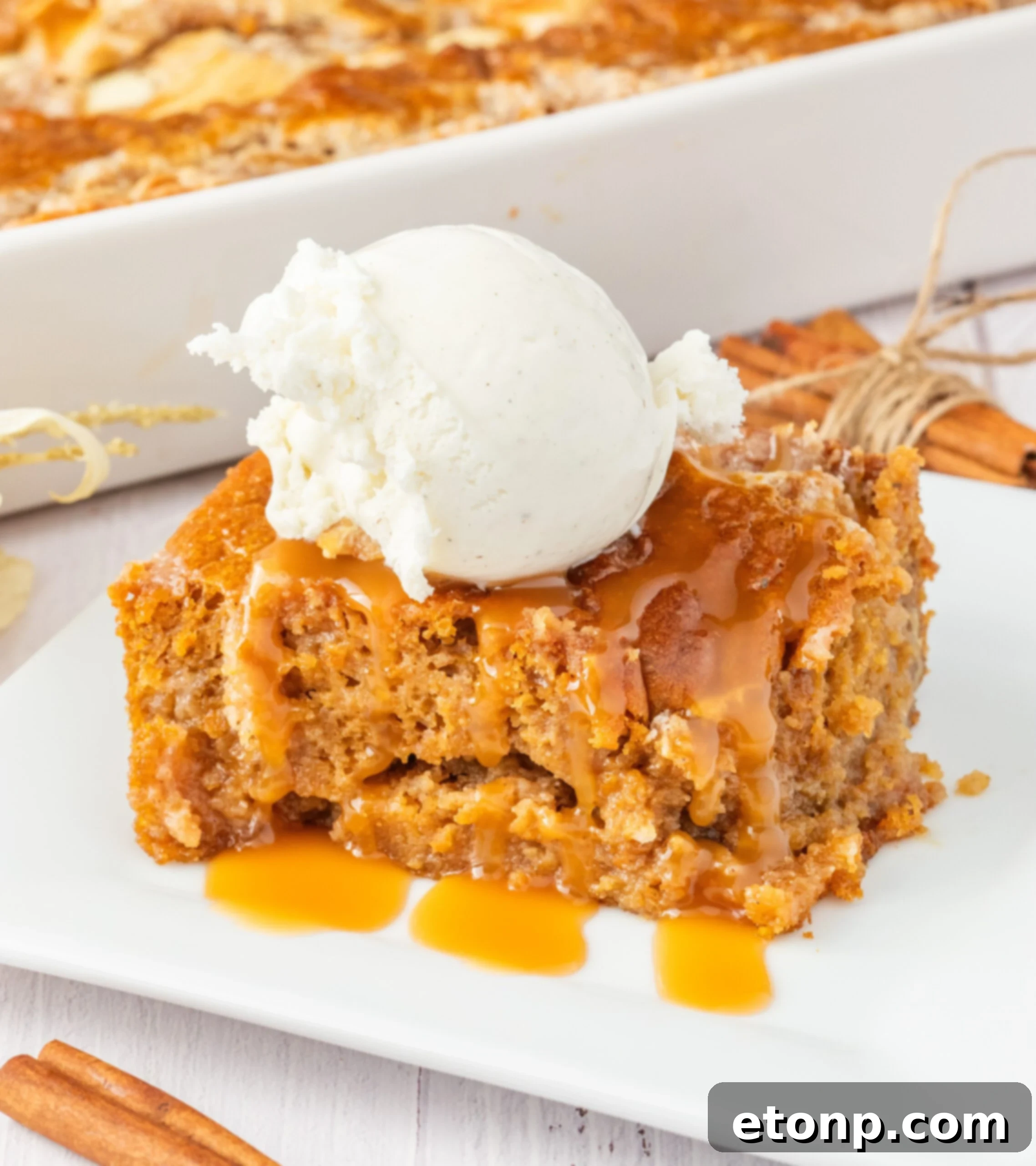 sliced earthquake cake on plate drizzled with caramel and a scoop of vanilla ice cream 