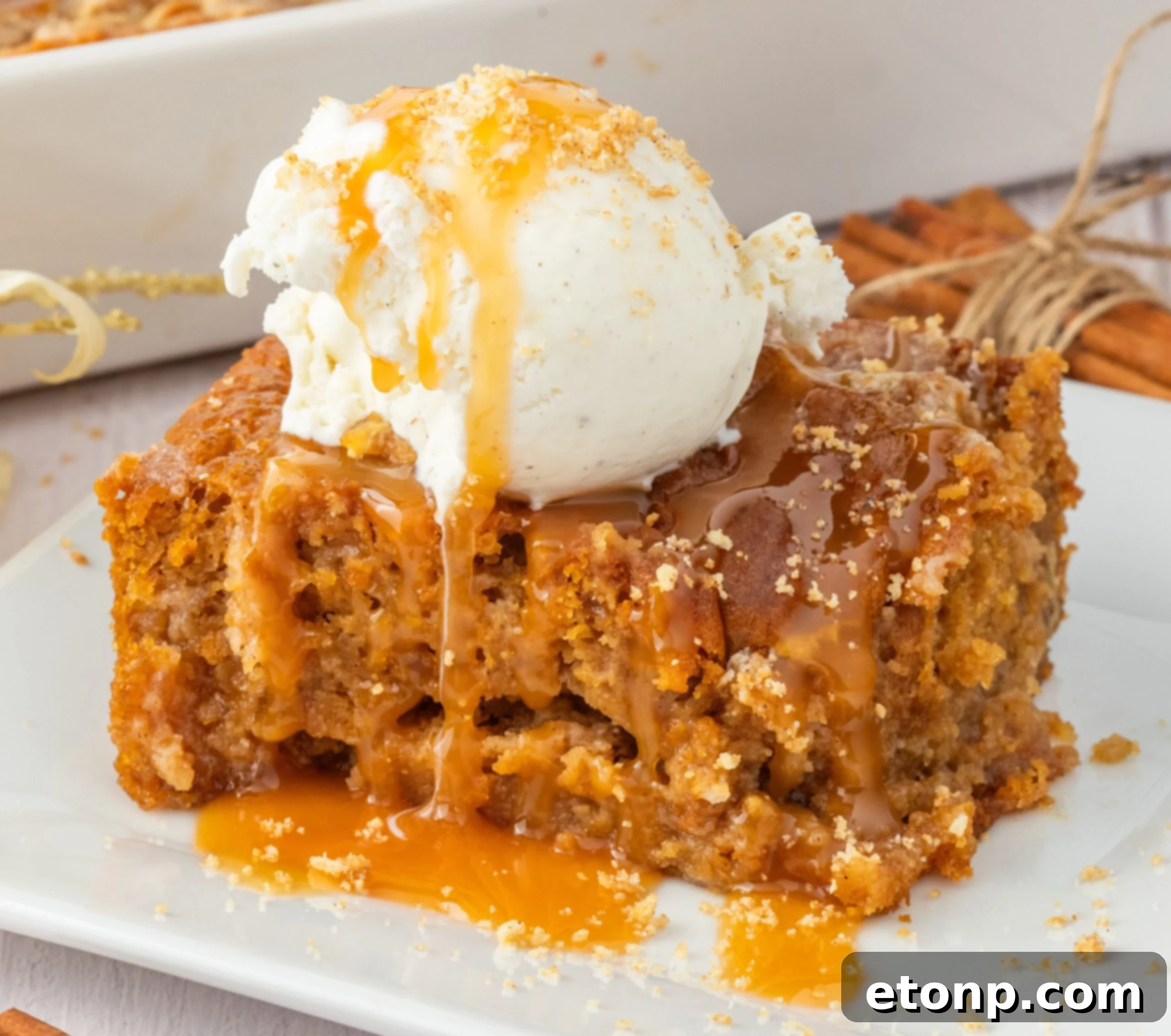sliced earthquake cake on plate drizzled with caramel and a scoop of ice cream on top