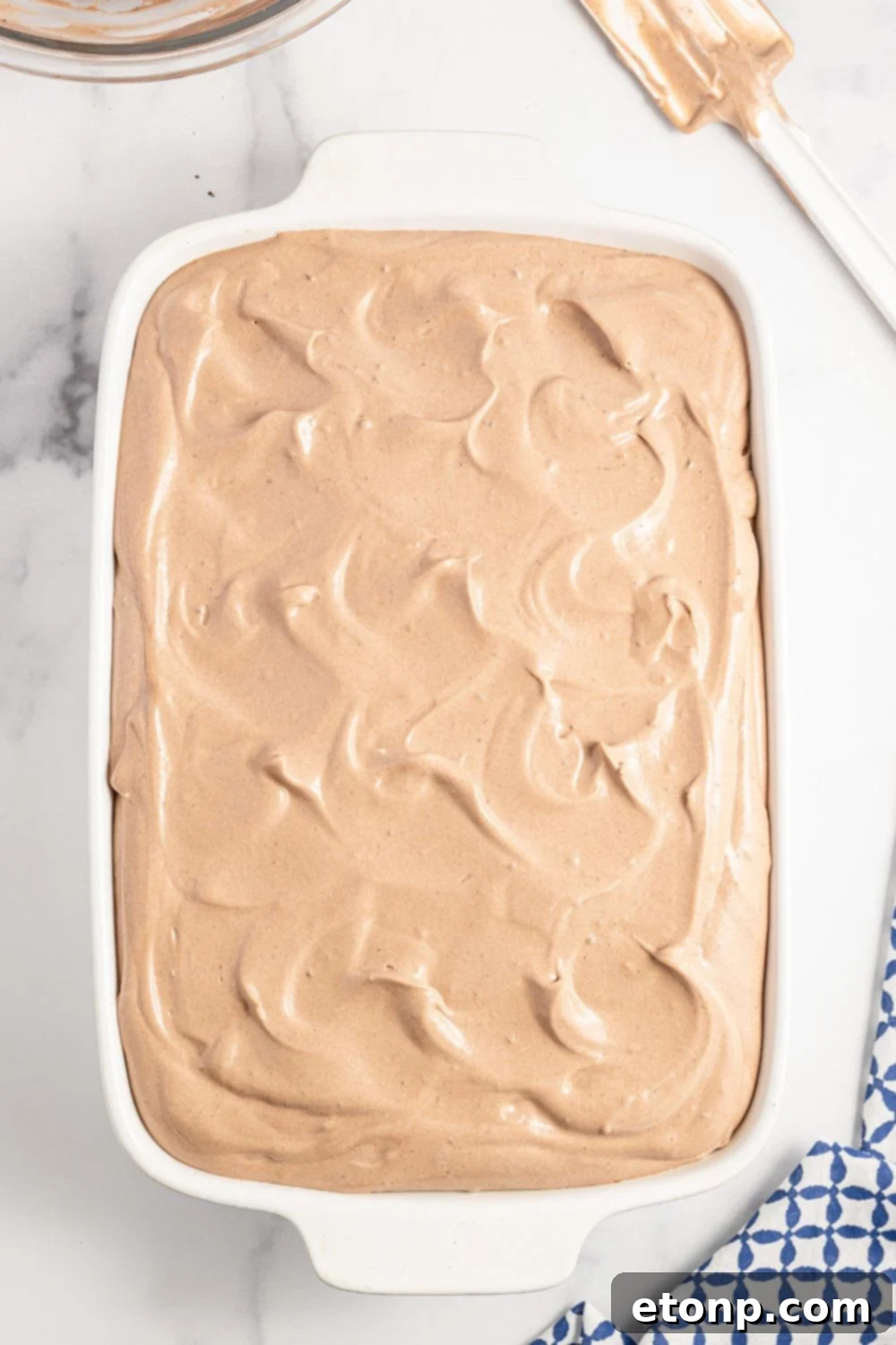 Dolce Vita Cake 11 chocolate pudding frosting being spread evenly on top of the cooled Italian Love Cake