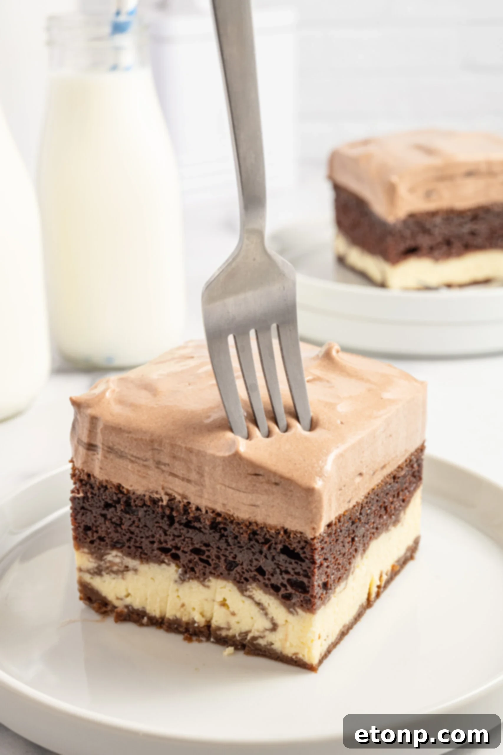 Dolce Vita Cake 14 Italian Love Cake sliced on a plate with a fork taking a bite, showing the soft texture