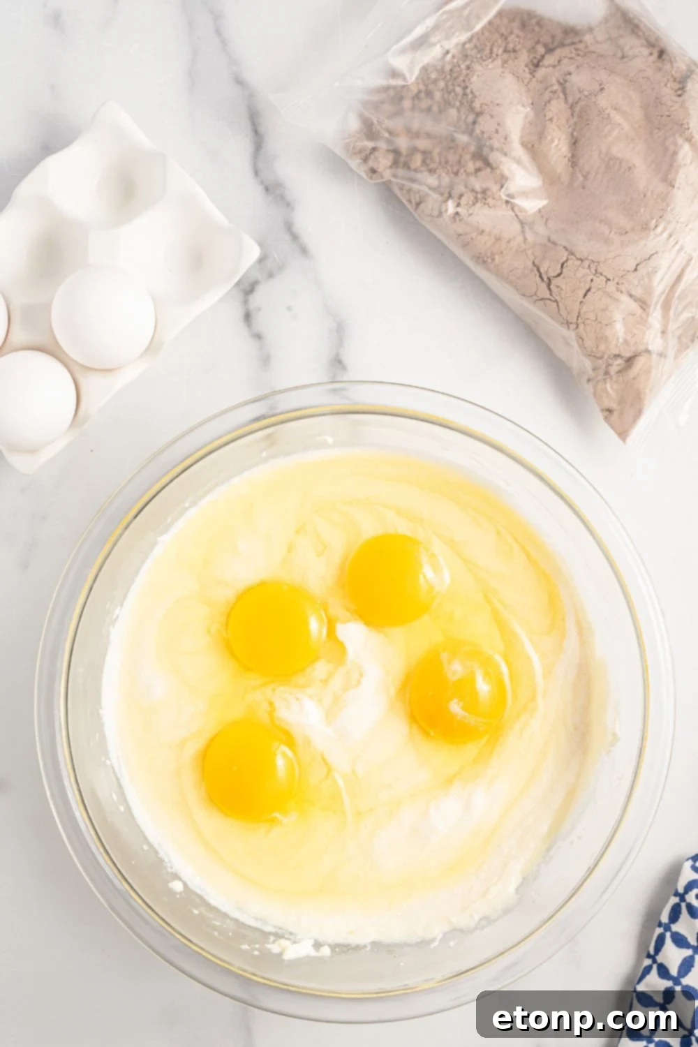 Dolce Vita Cake 7 eggs being mixed into ricotta mixture in a glass bowl
