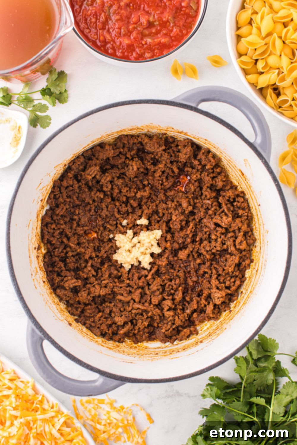Cheesy Taco Pasta 10 Cooked and seasoned ground beef in a pot, ready for the next step of the taco pasta recipe.