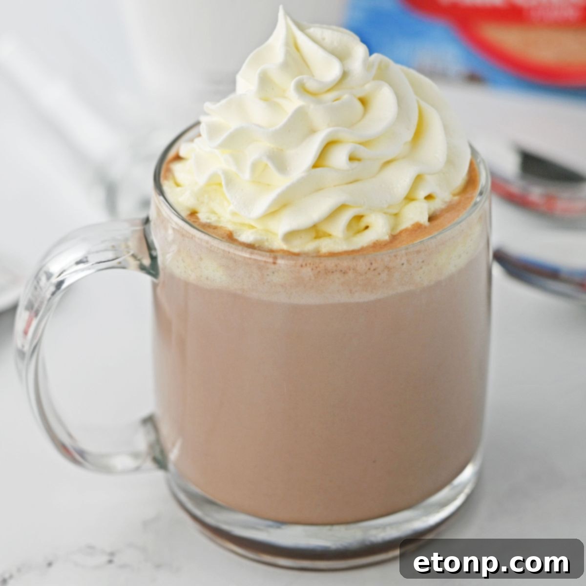 rumchata hot chocolate on a white table topped with whipped cream