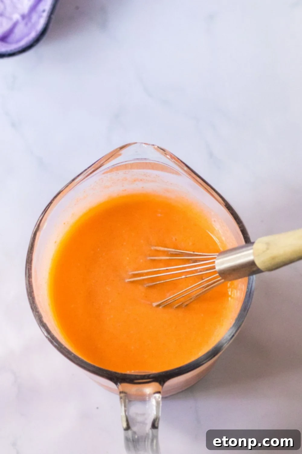 orange jello mixture in measuring cup 