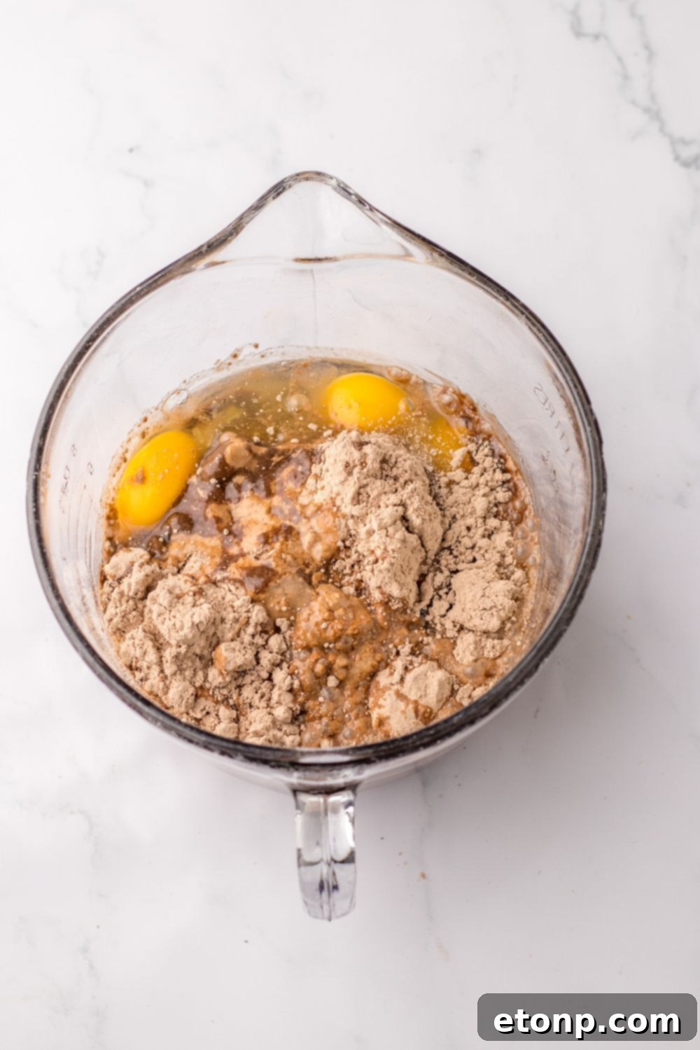 chocolate cake mix with ingredients in a measuring cup on table 
