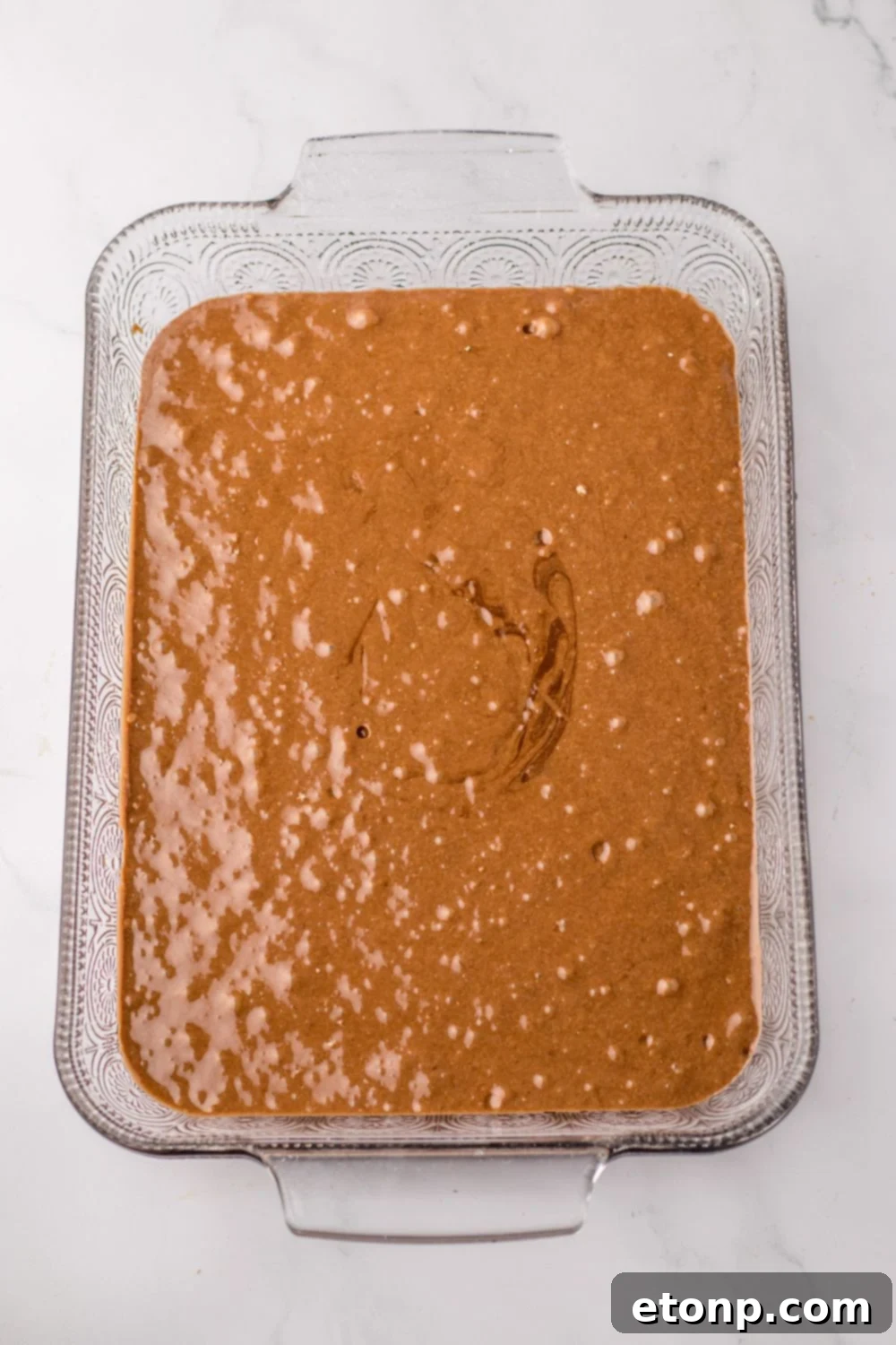 chocolate cake batter in a 9x13 baking dish on table 
