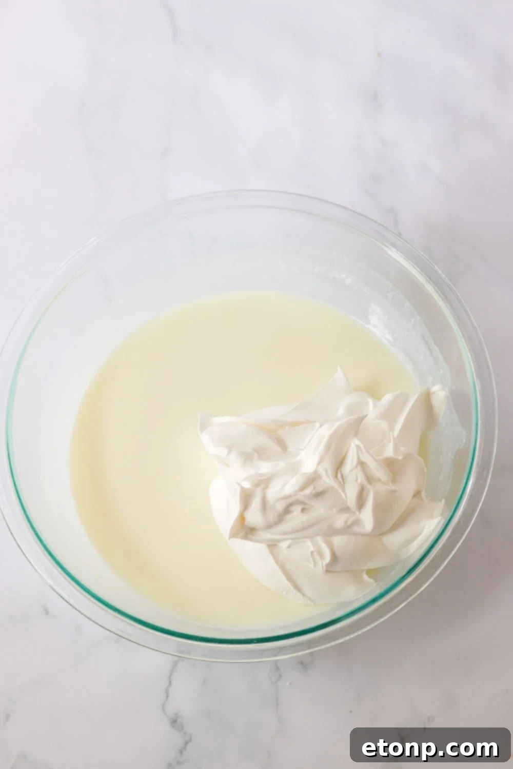 jello and whipped cream in a glass bowl