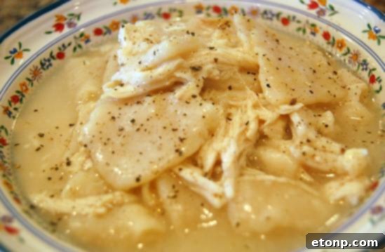 Homemade Cracker Barrel-style Chicken and Dumplings, featuring thick, flat dumplings in a rich chicken broth.