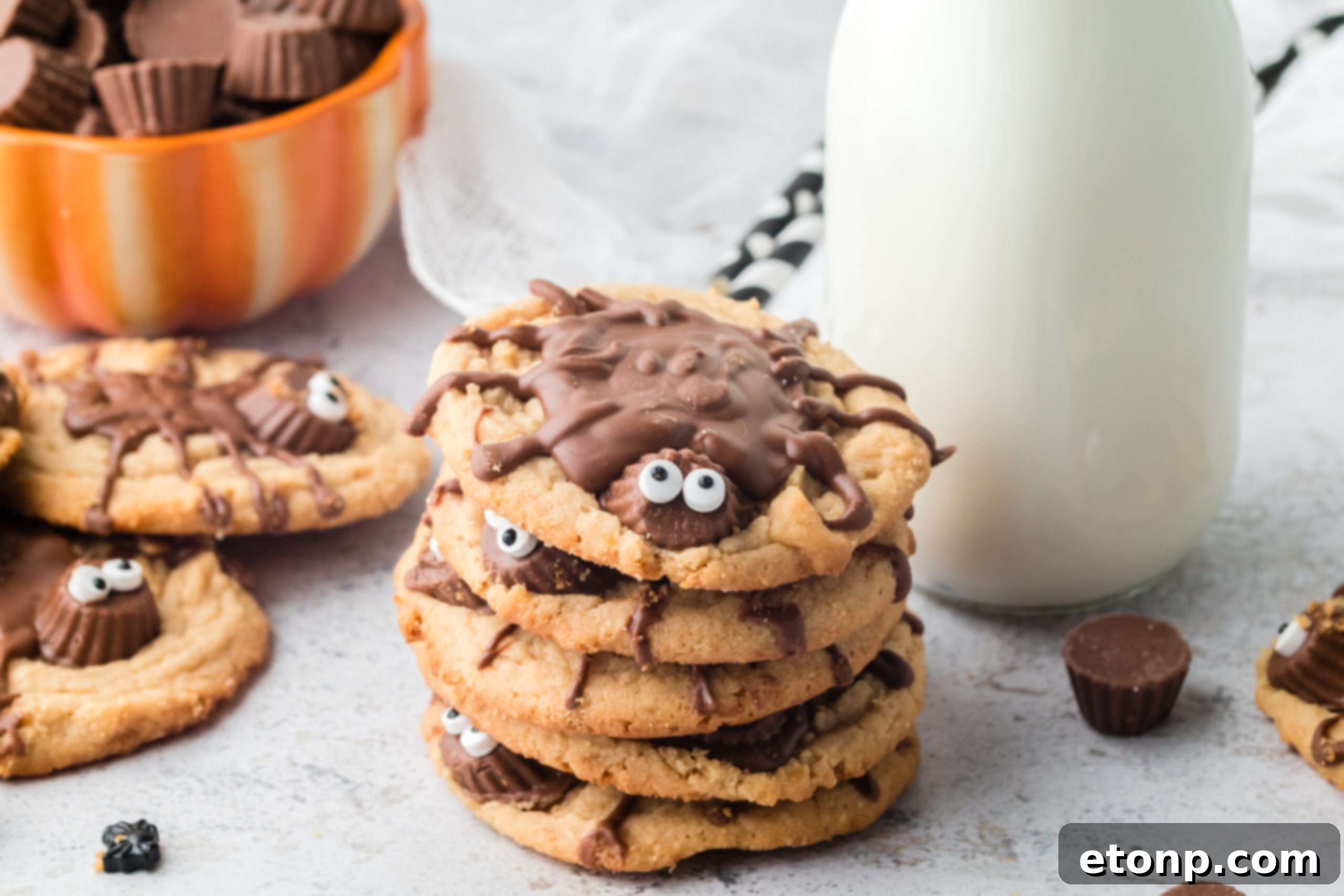 Frightfully Delicious Peanut Butter Spider Cookies 15 Peanut Butter Spider Cookies stacked on a table with a glass of milk next to them