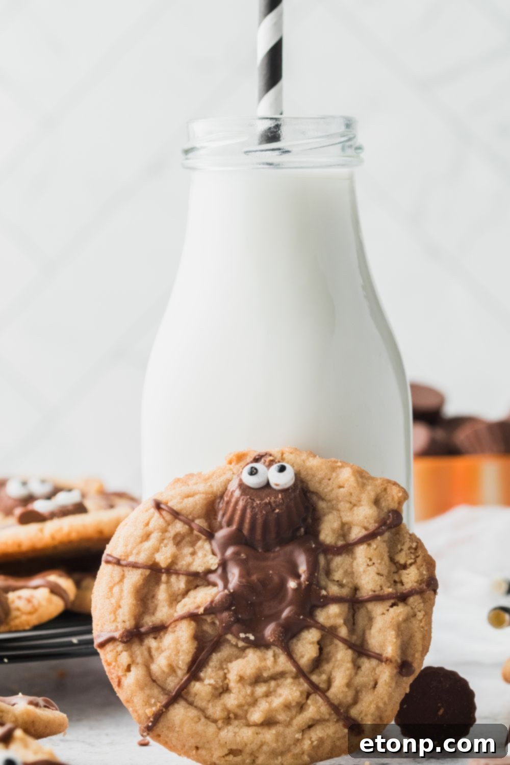 Frightfully Delicious Peanut Butter Spider Cookies 16 cookie tilted up on milk jug on counter