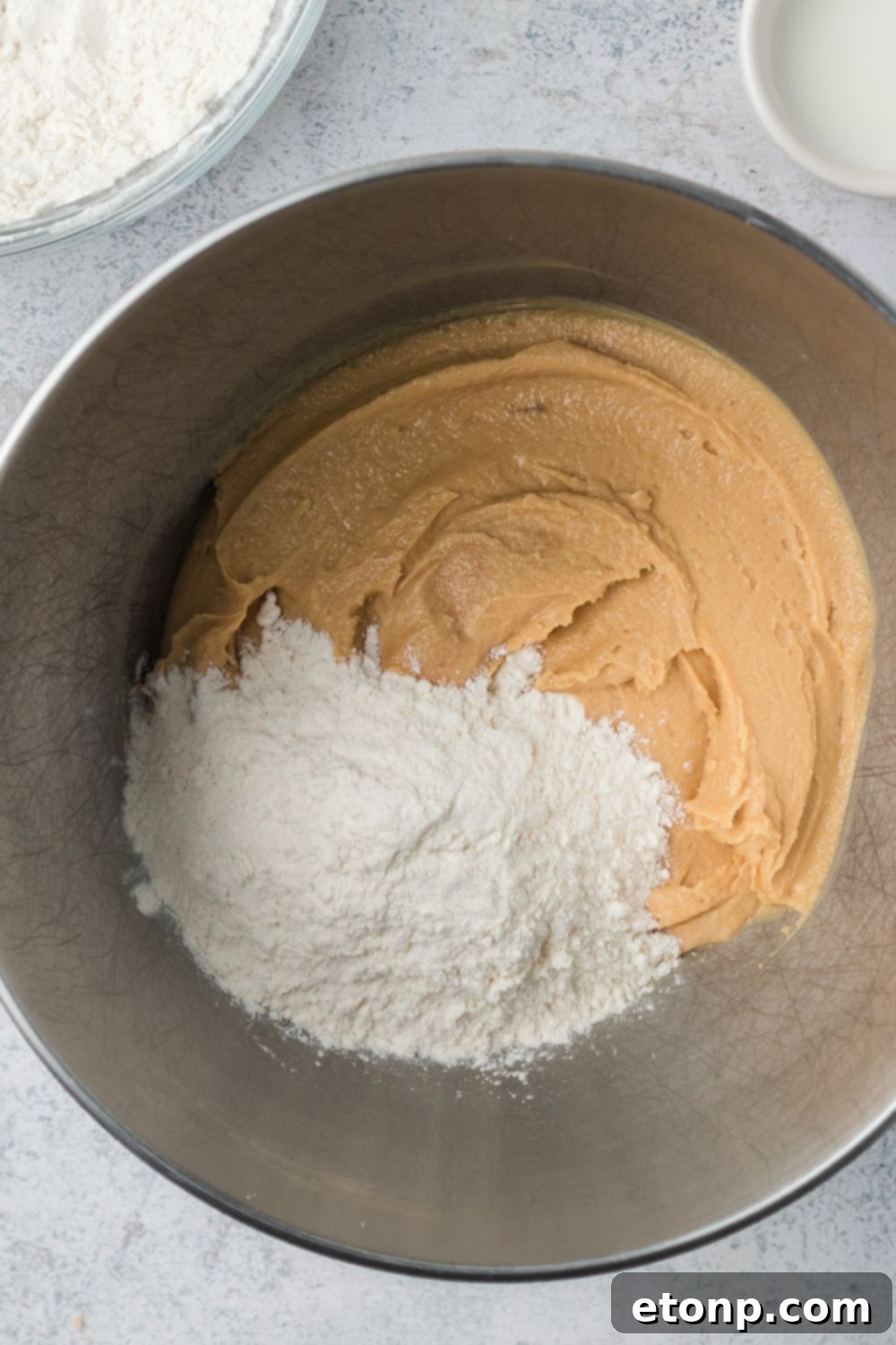 Frightfully Delicious Peanut Butter Spider Cookies 10 peanut butter cookie dough in a mixing bowl with flour poured in it