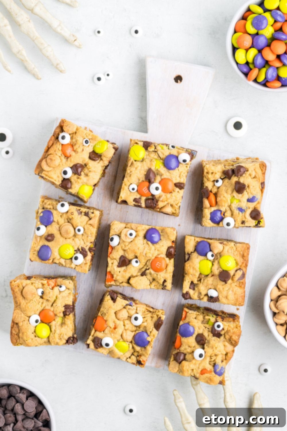 bars scattered on table with Halloween decorations around it and a bowl of M&Ms