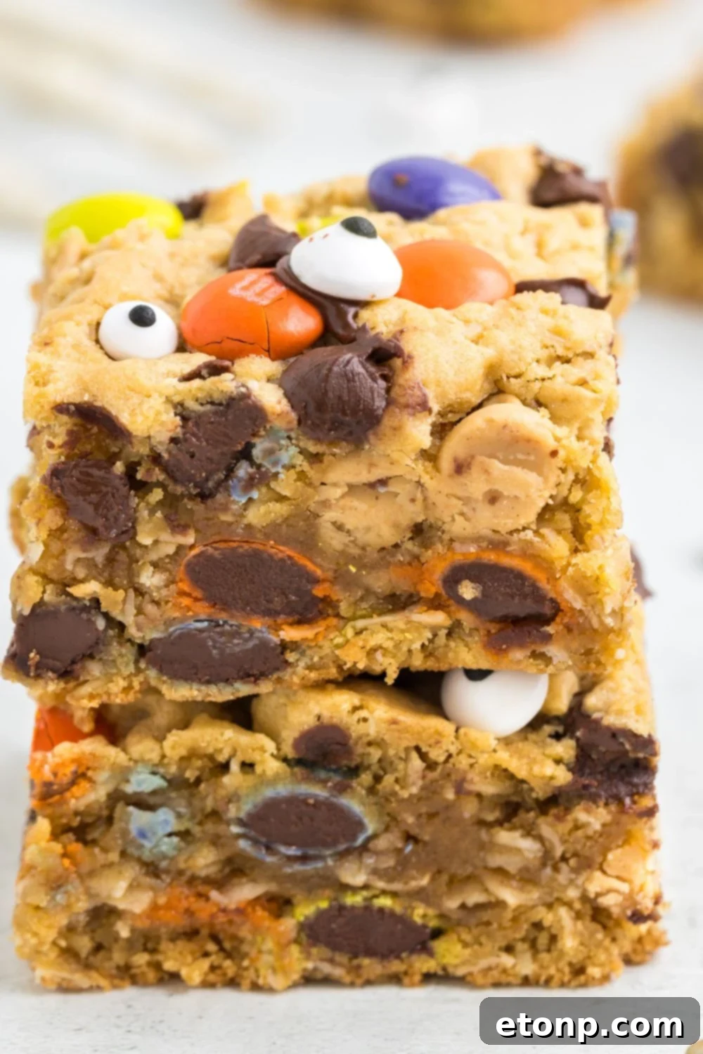 chewy bars stacked on top of each other on tale with cookie bars around it