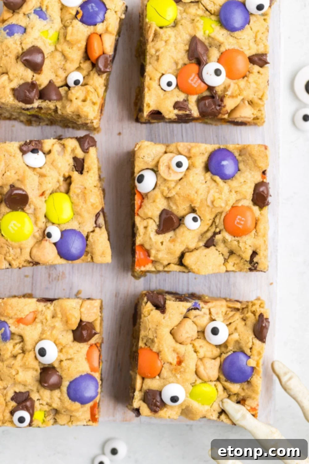 Halloween Monster Cookie Bars set out on table with halloween decor around them
