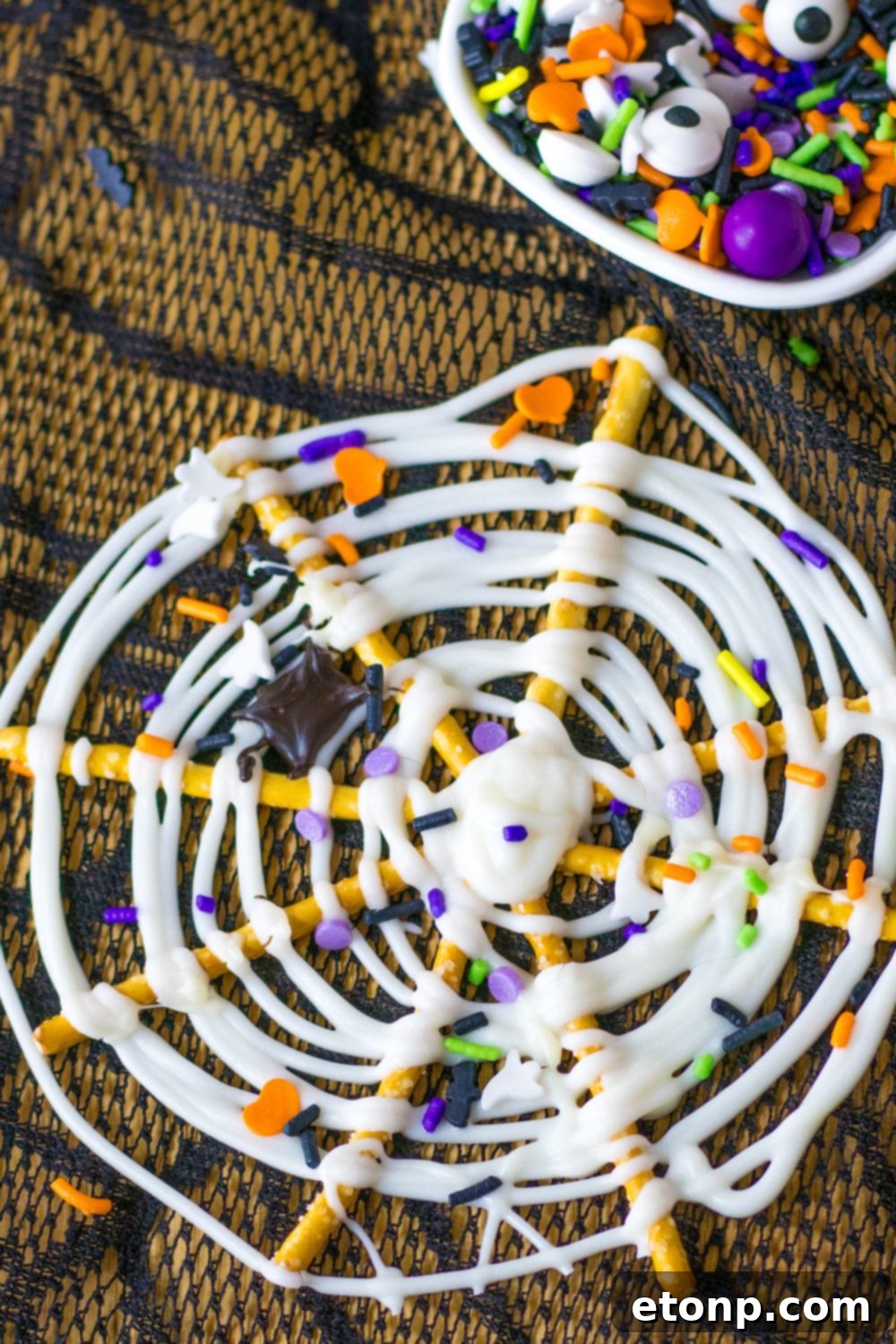 Close up of pretzels on a table with a container of sprinkles in the background