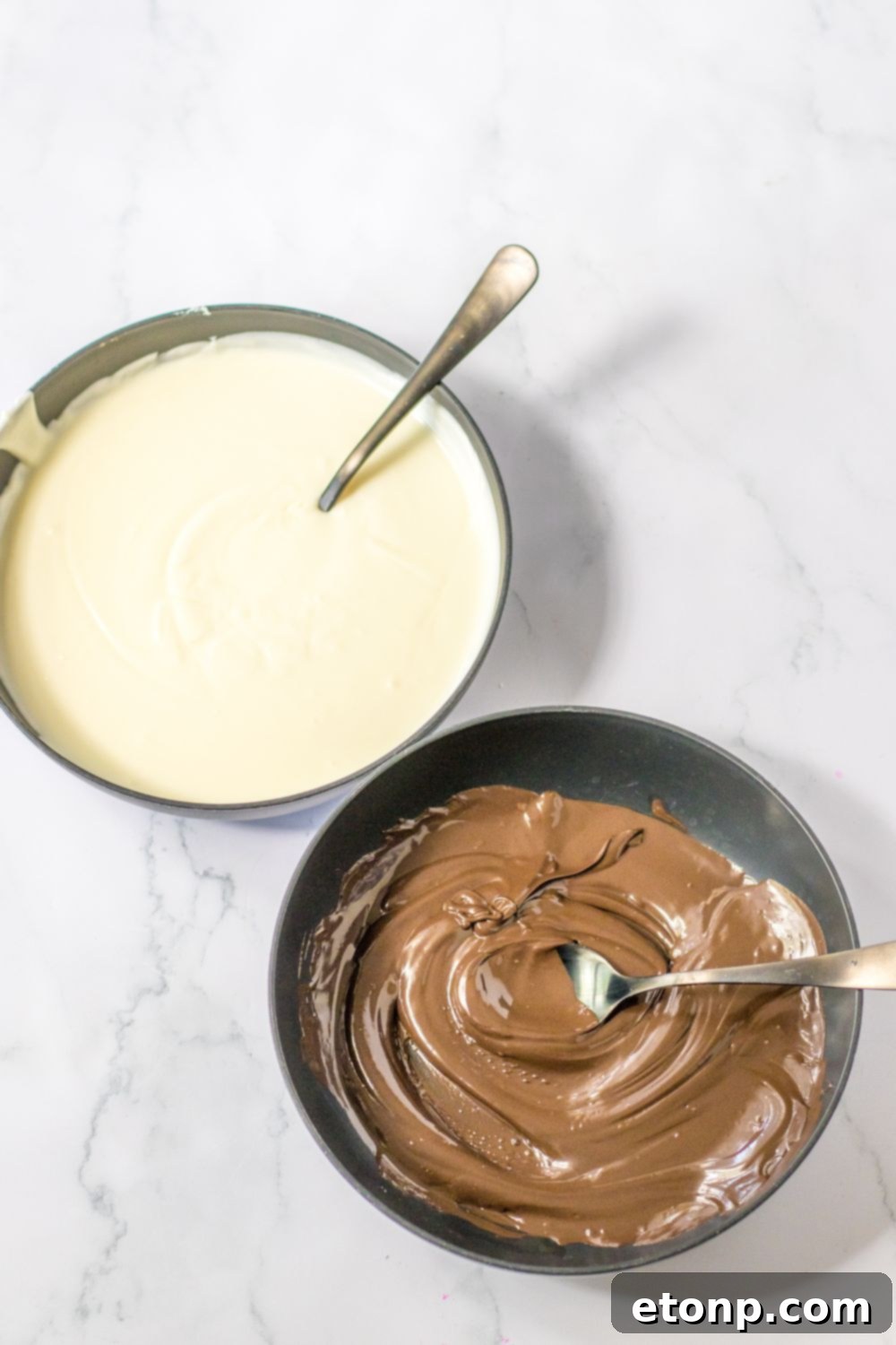 Bowls of melted white and dark chocolate on a table