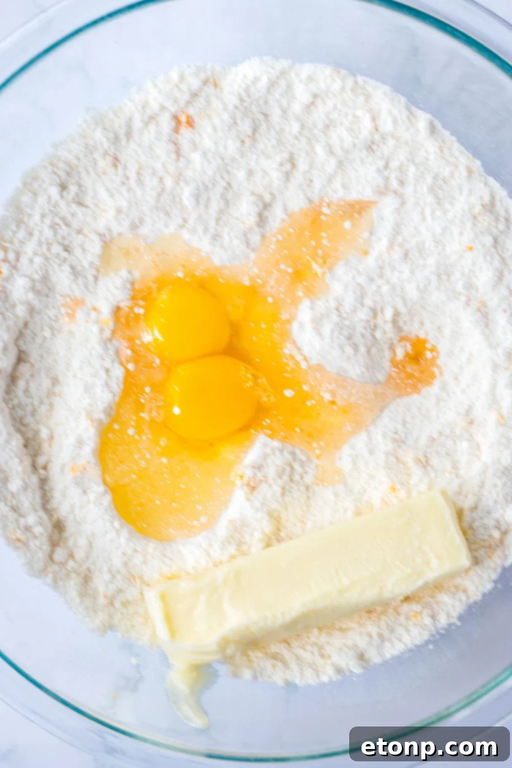 butter and egg mixture on top of cake mix batter 