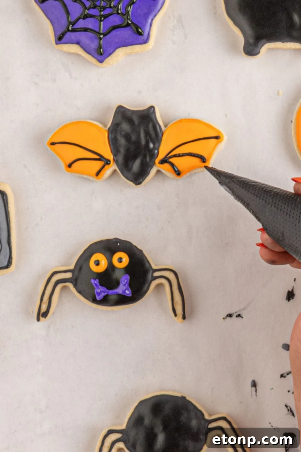 adding lines to a bat cookie with royal icing 