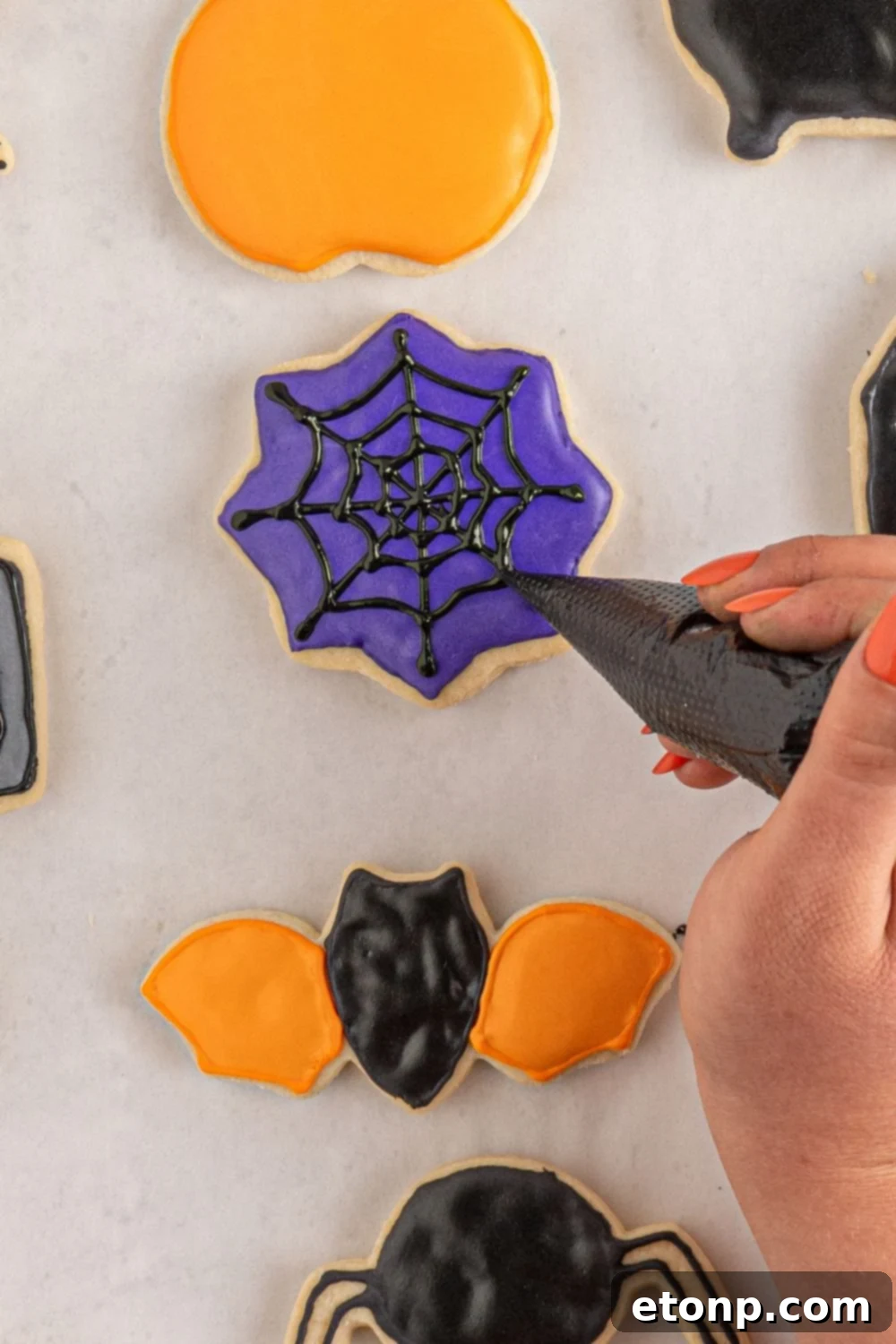 drawing spider web on sugar cookie 