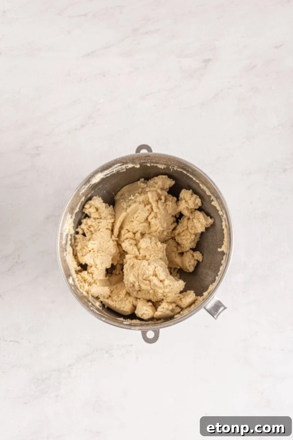 overhead shot of sugar cookie dough formed in a bowl on table 