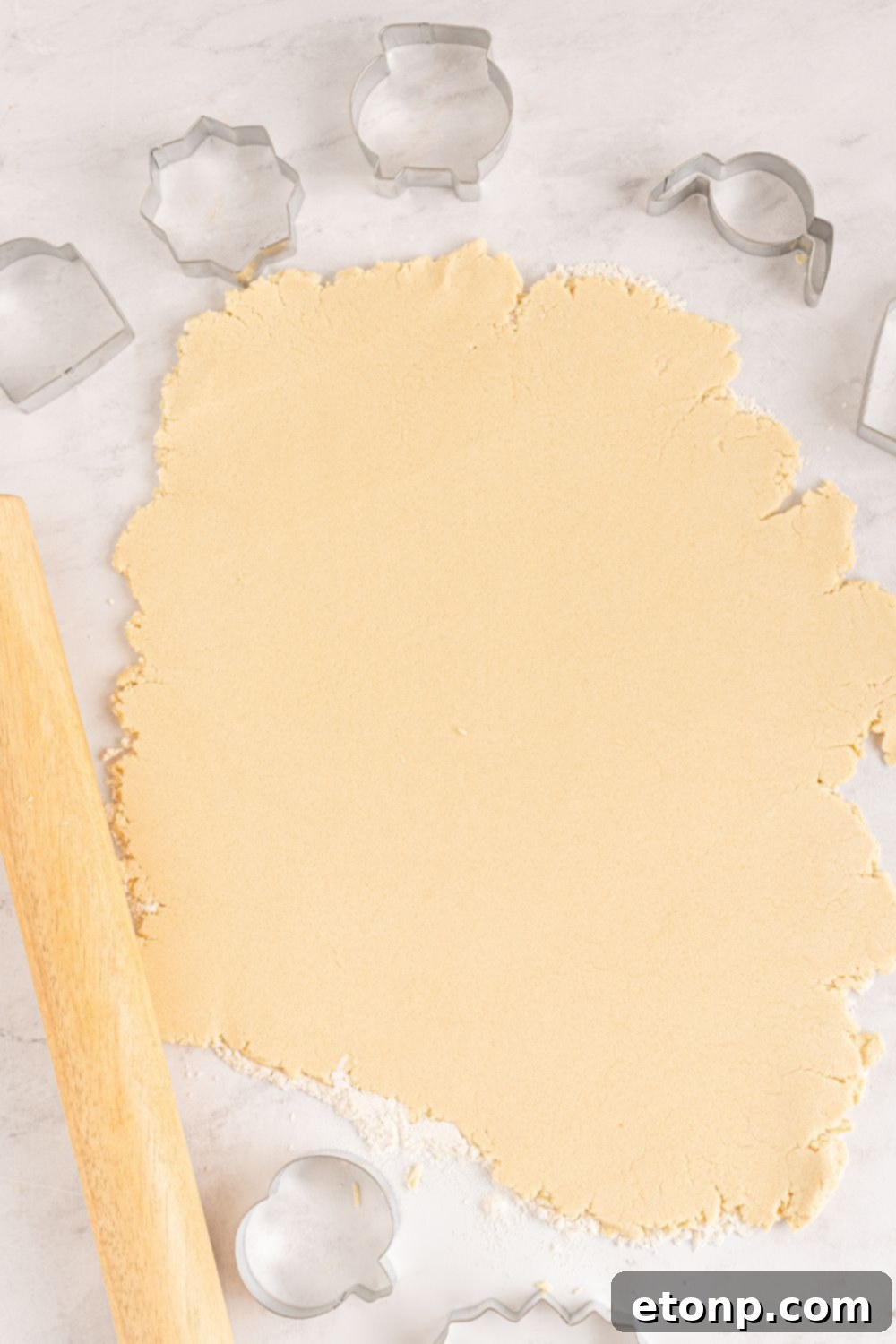 rolled out sugar cookie dough on table 
