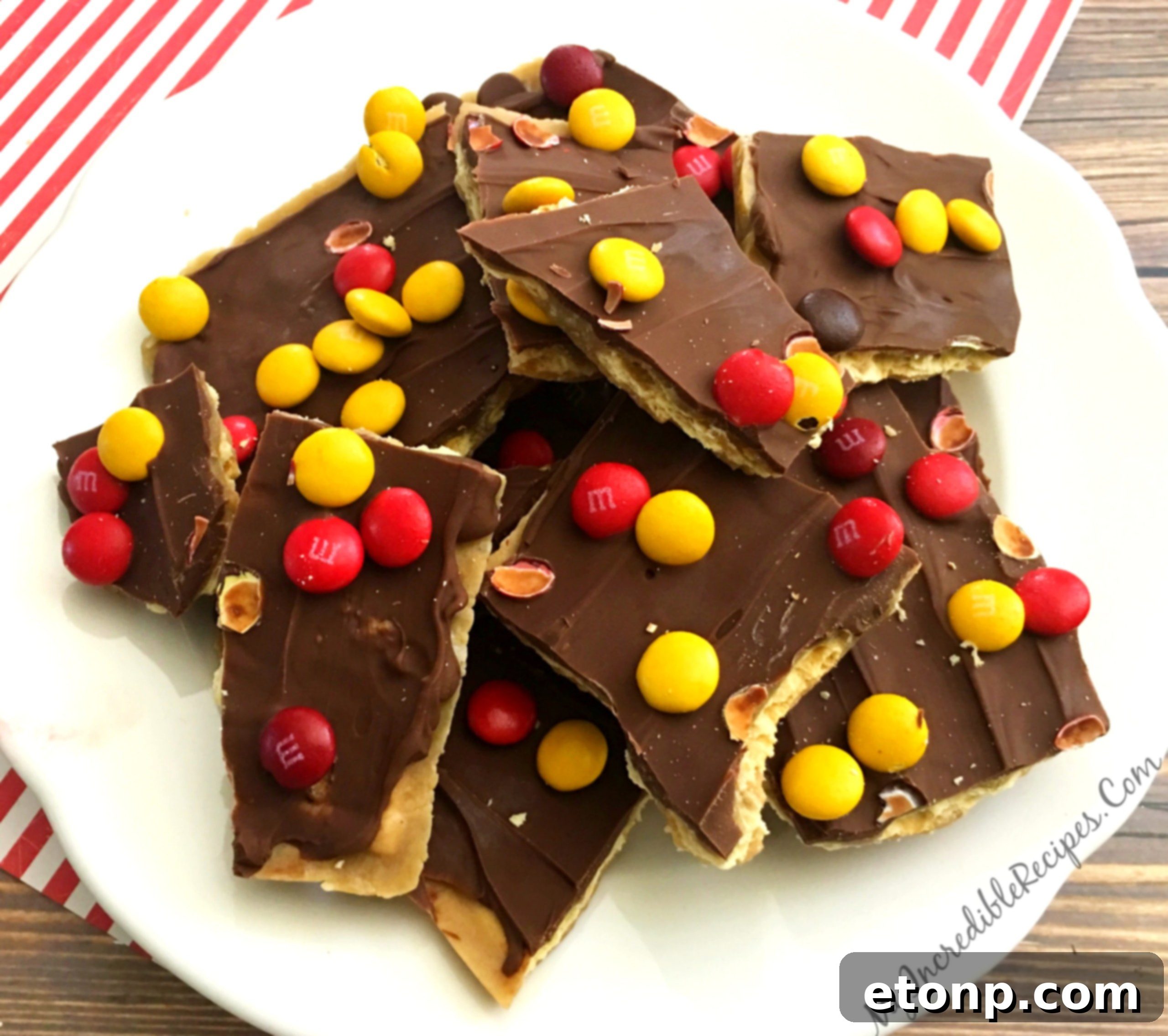 A pan full of finished saltine cracker toffee, glistening with chocolate and toppings