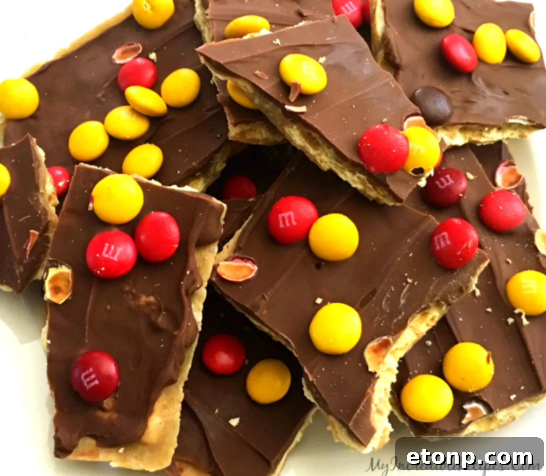 Broken pieces of saltine cracker toffee with chocolate and M&Ms, ready to eat