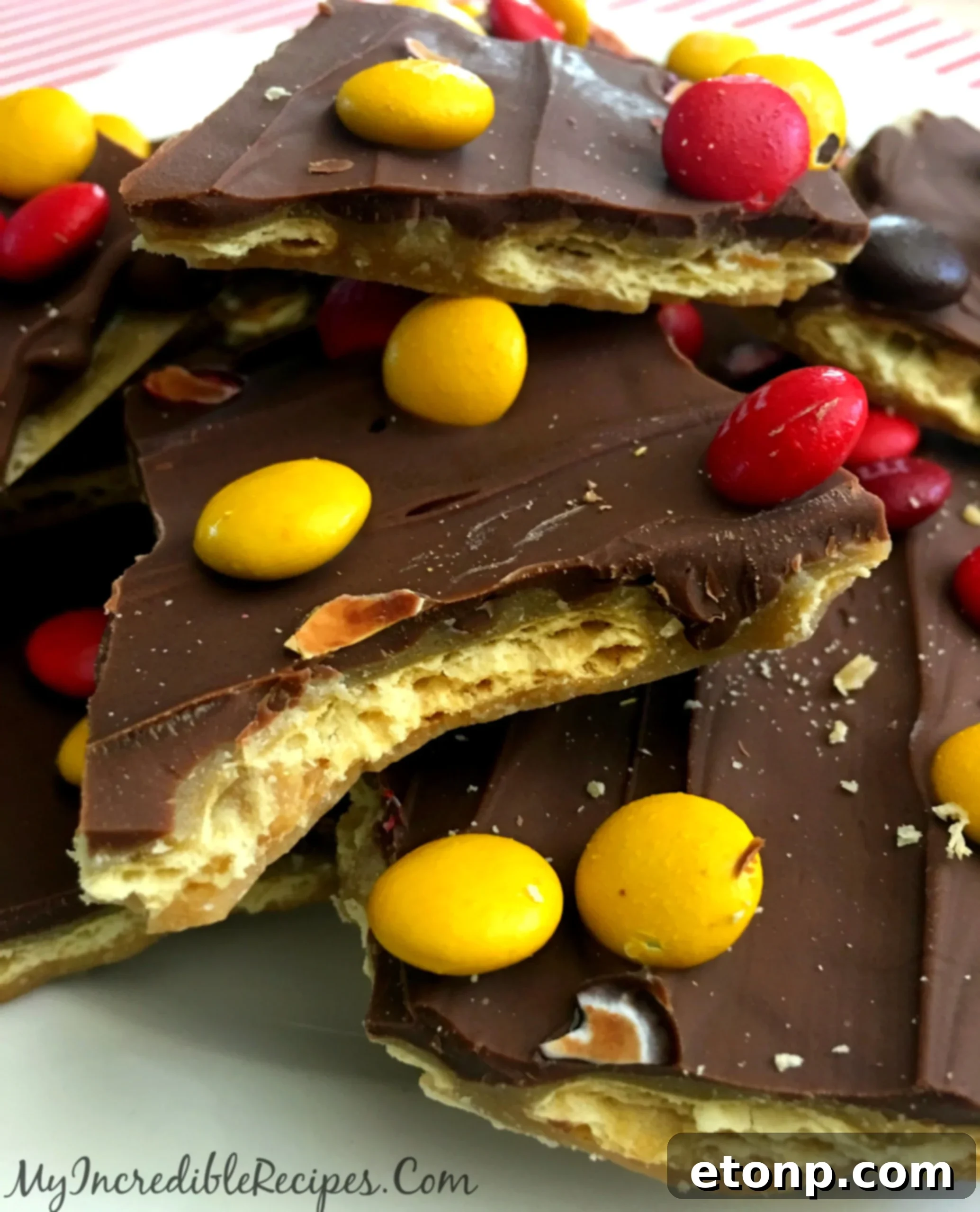 A large pile of freshly broken saltine toffee crack pieces with chocolate and various candies