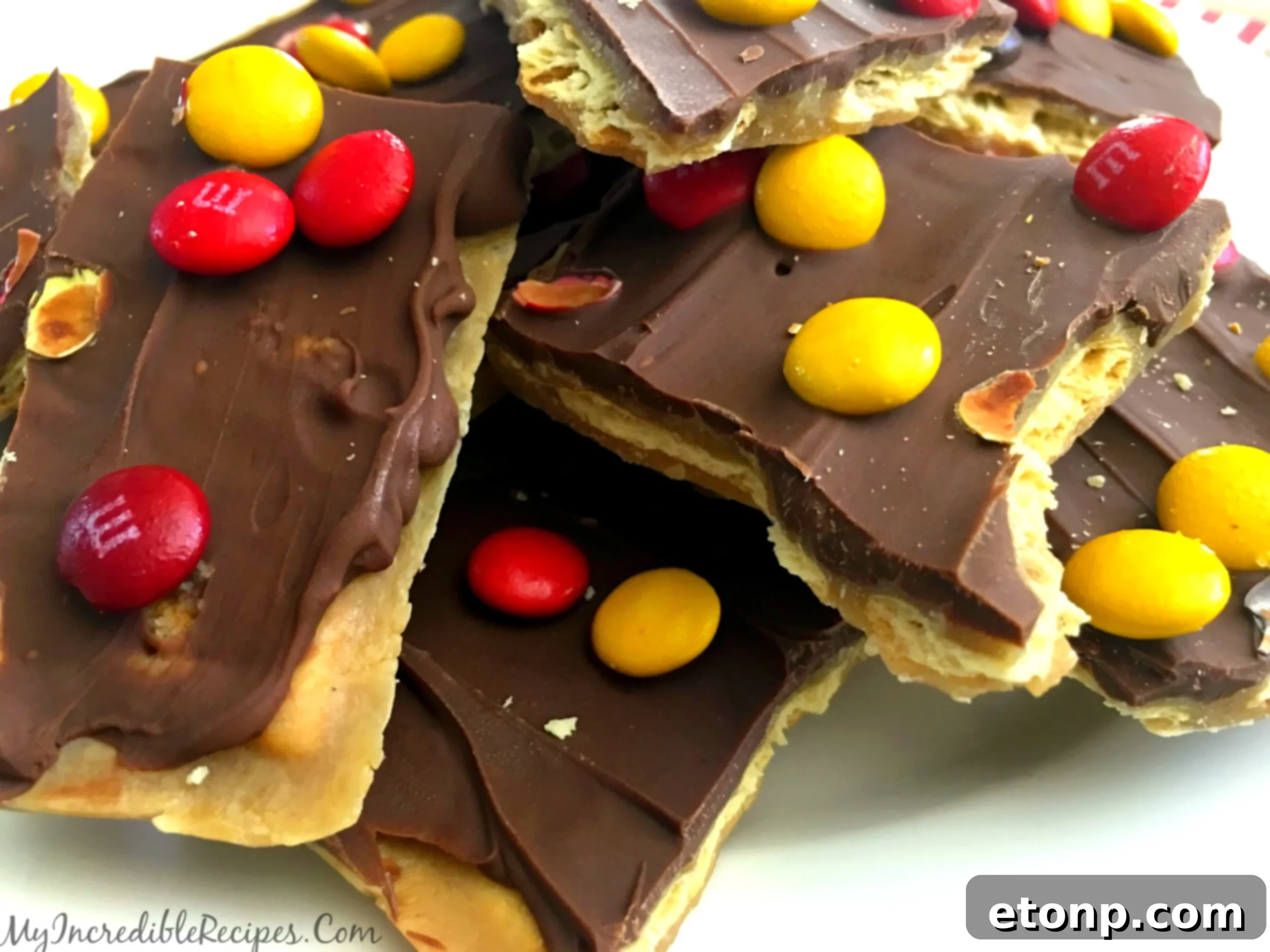 Close-up of a few golden pieces of saltine toffee, showcasing the crisp texture and chocolate layer