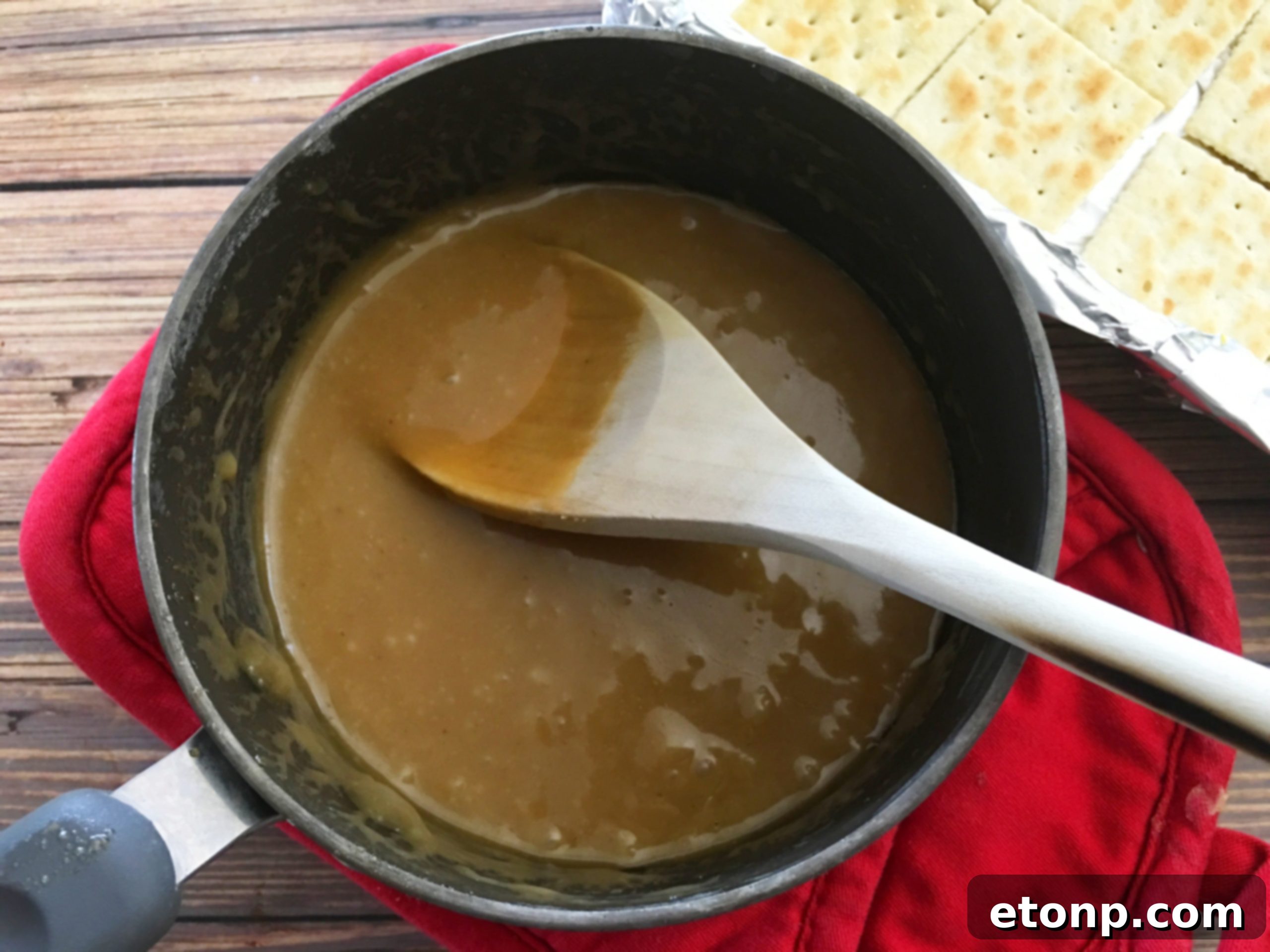 Golden brown butter and brown sugar mixture boiling in a saucepan, forming toffee