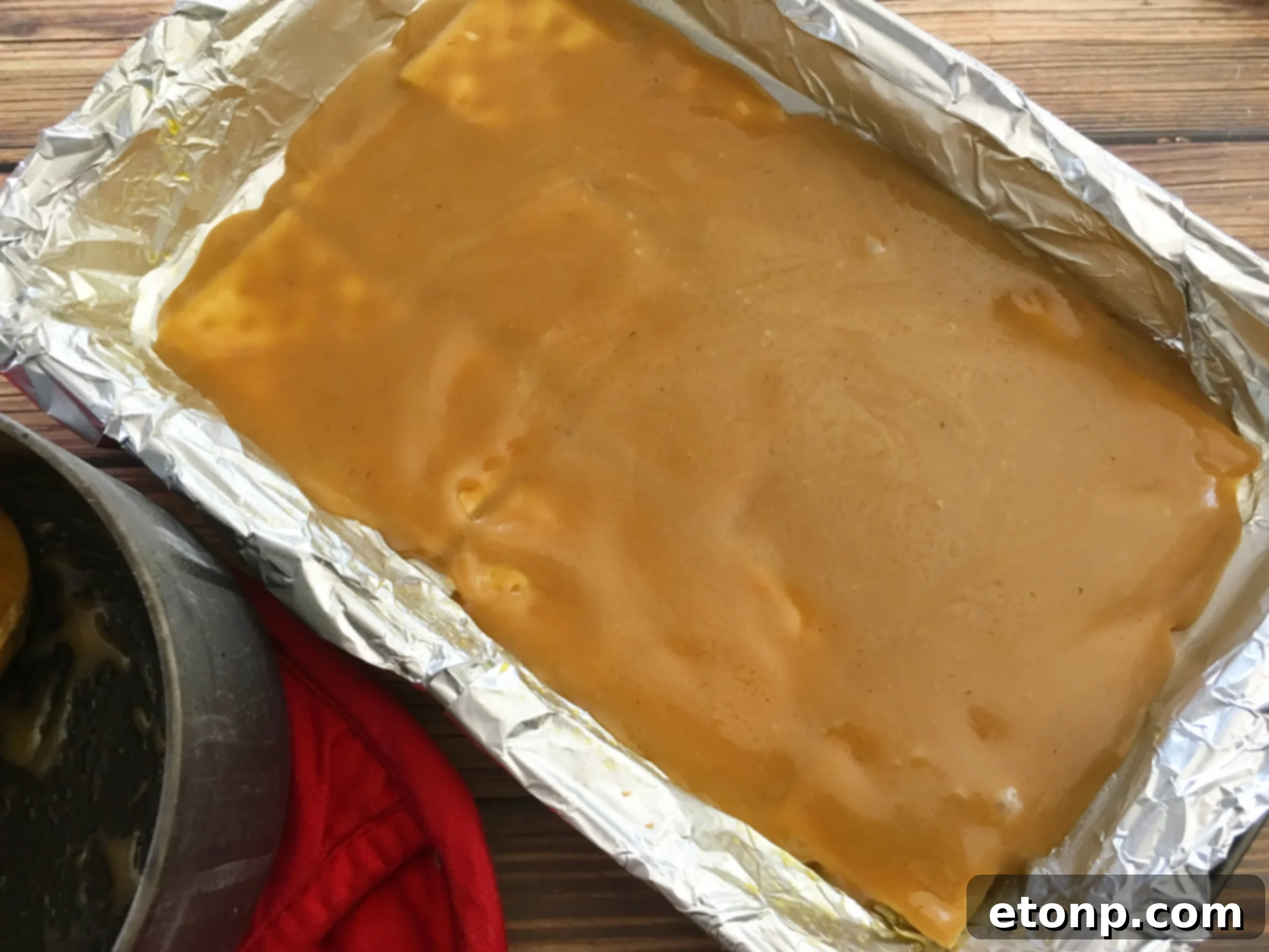 Melted chocolate chips spread evenly over baked toffee-coated saltine crackers