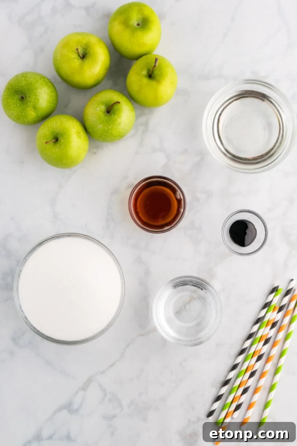 ingredients to make black candy apples sitting on marble counter top