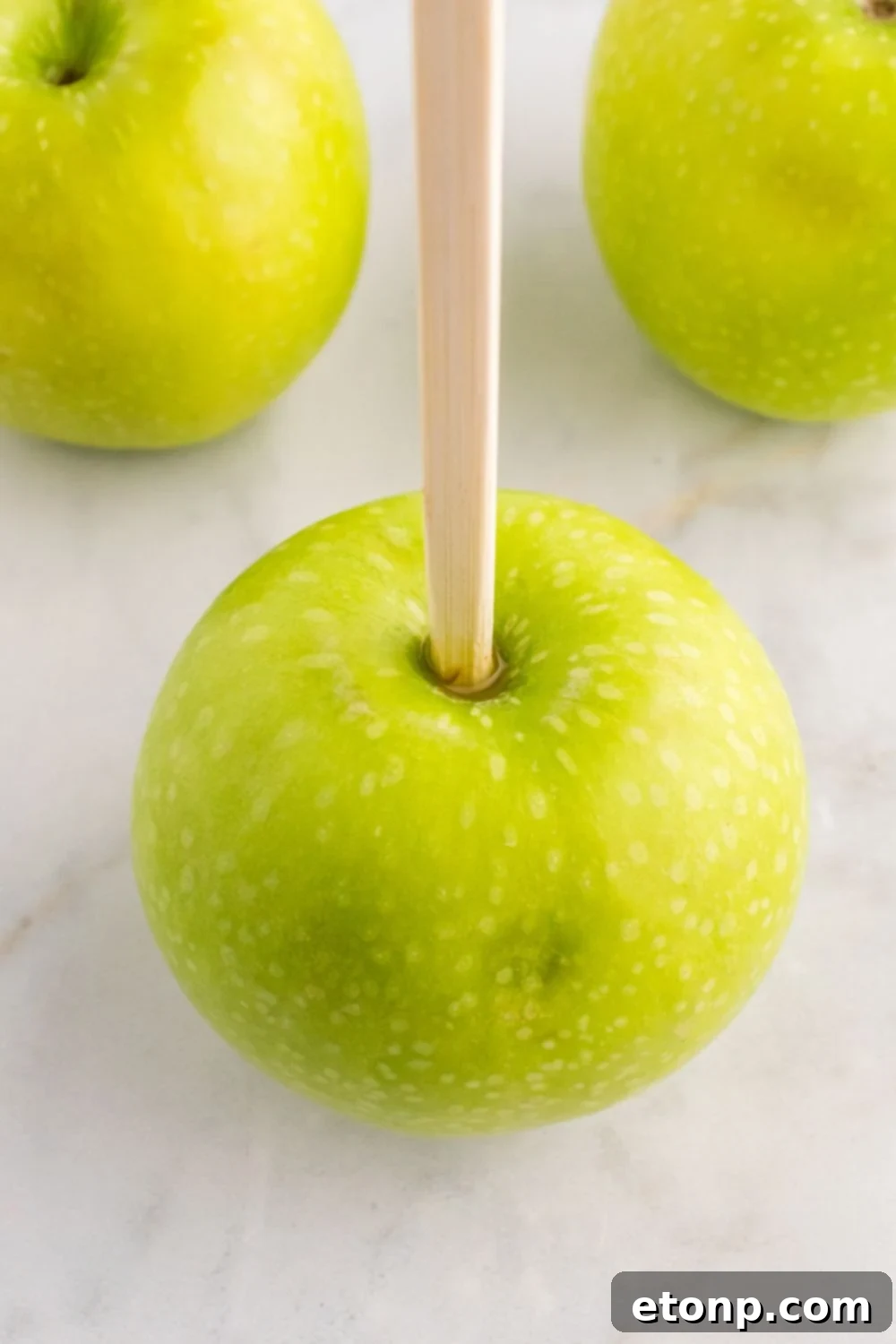 Granny Smith apples with a wooden skewer poked in top