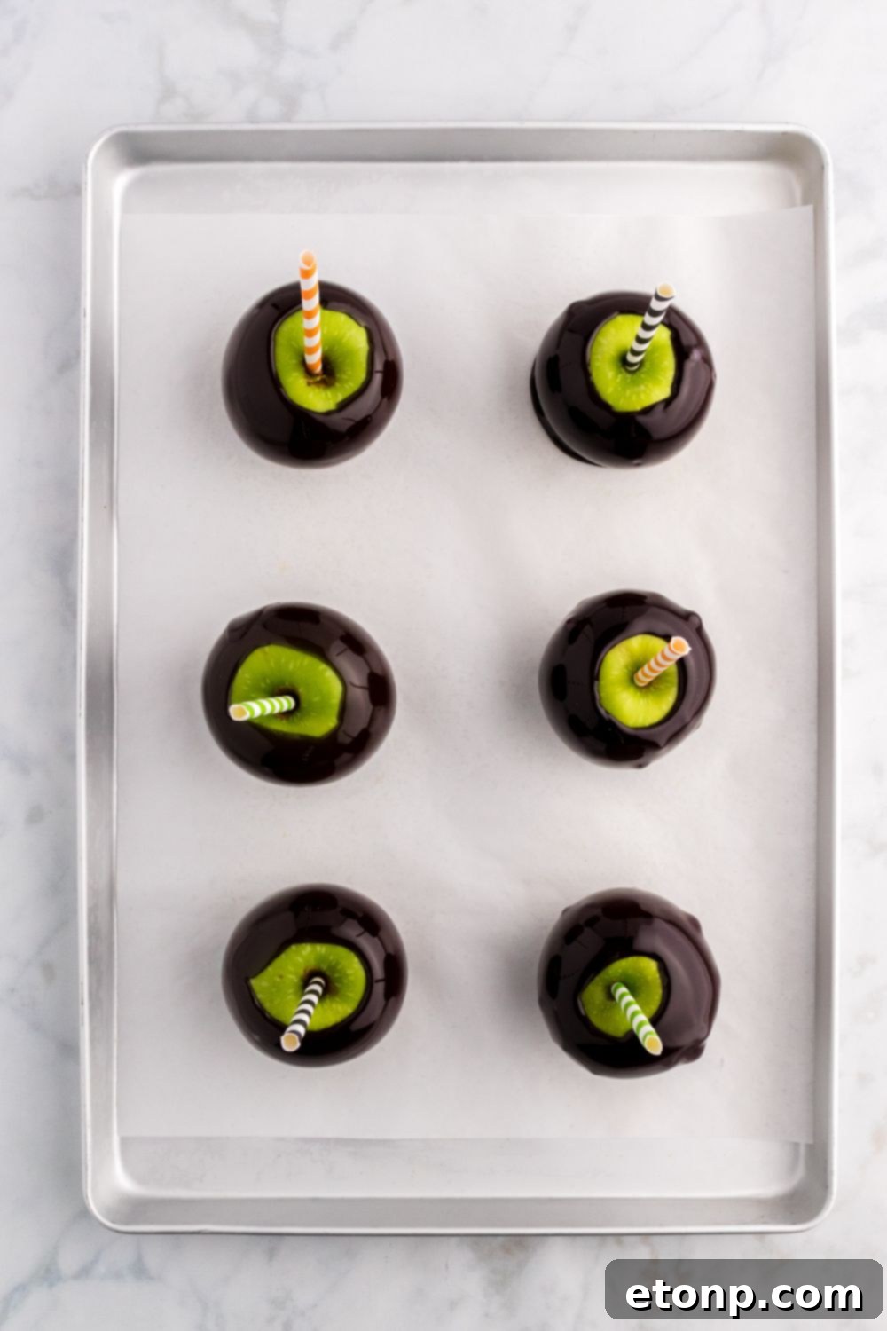 Black Candy Apples on a prepared cookie sheet 