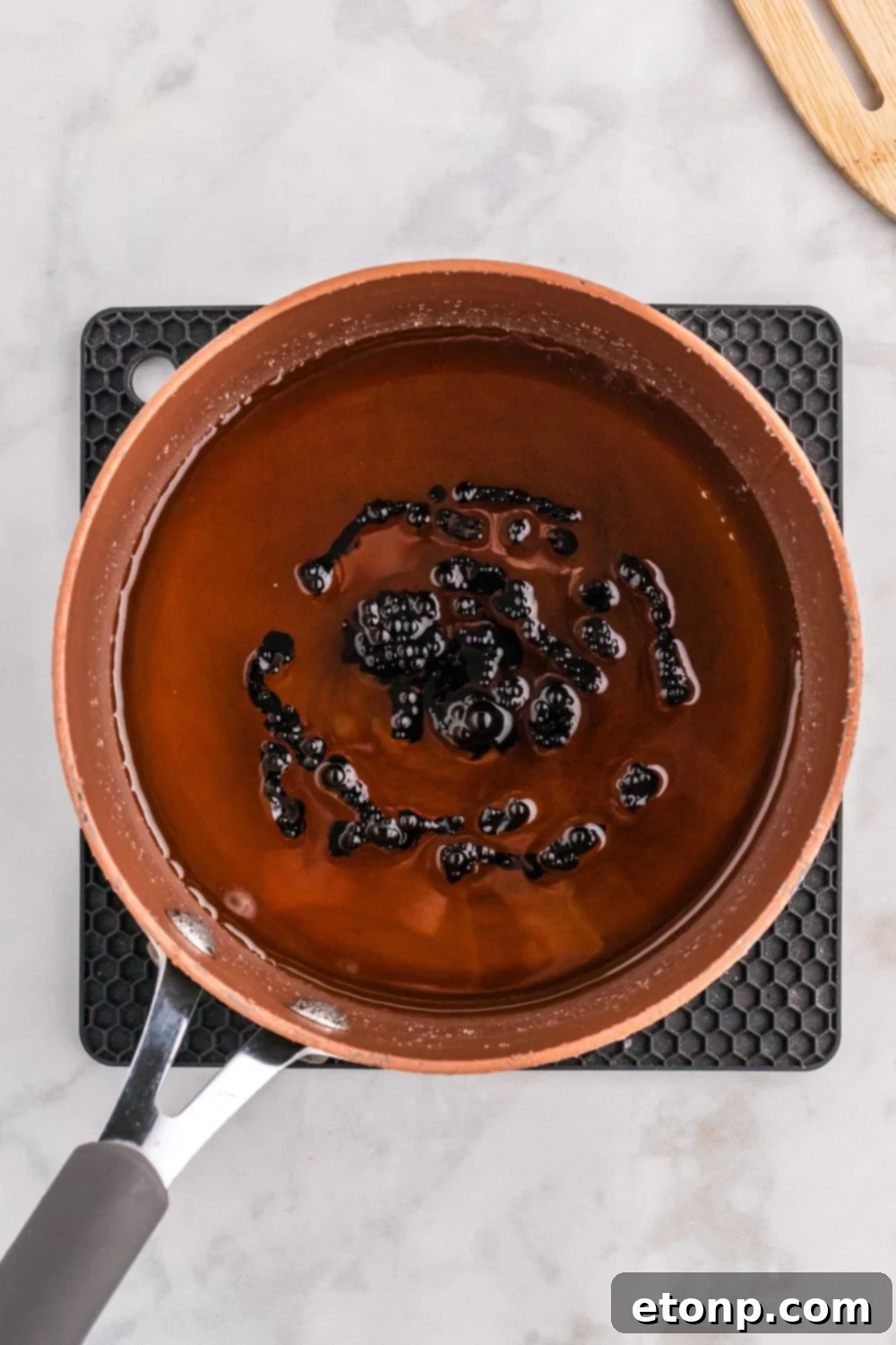 black food coloring added to pan of candy coating for apples