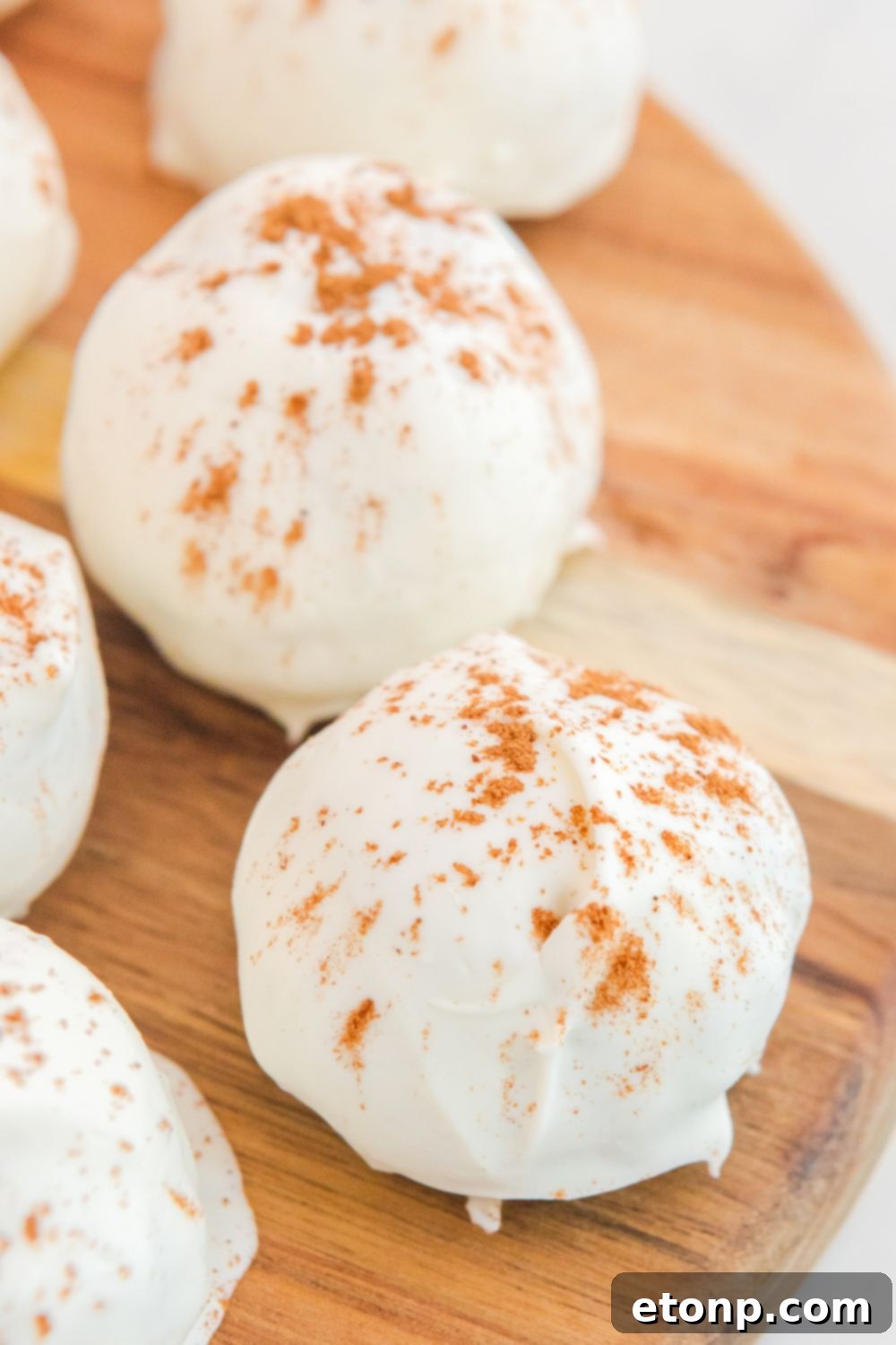 A rustic wooden cutting board laden with delicious pumpkin spice cake balls, inviting to be tasted.