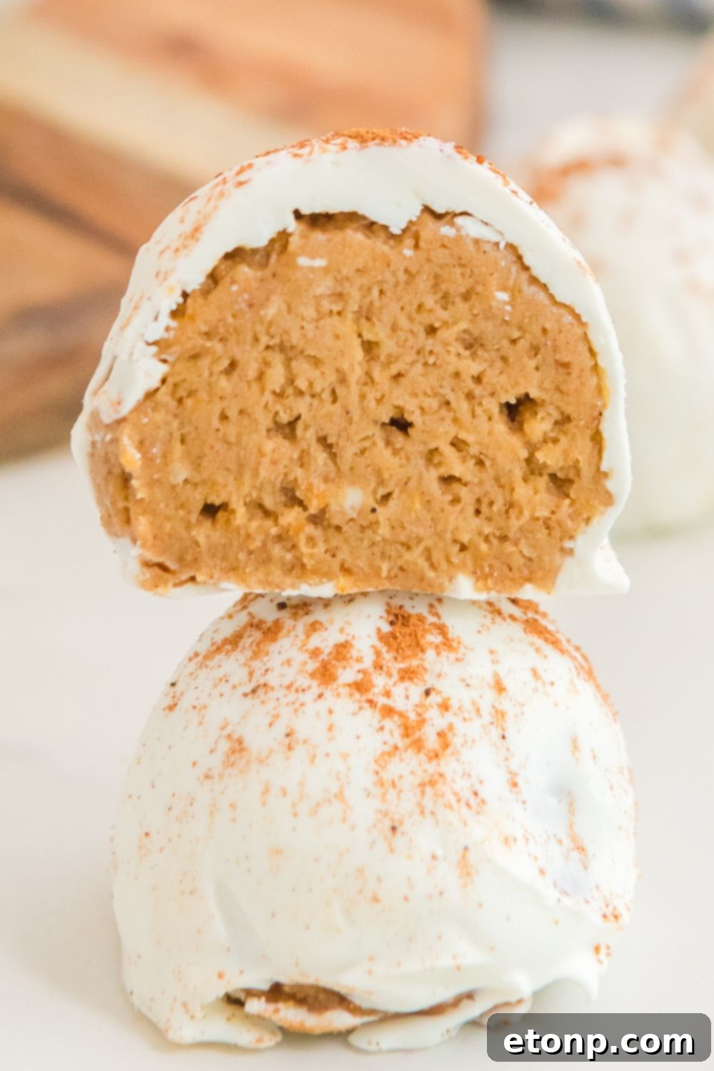 Pumpkin balls meticulously stacked on top of each other on a table, showcasing their uniform size and perfect coating.