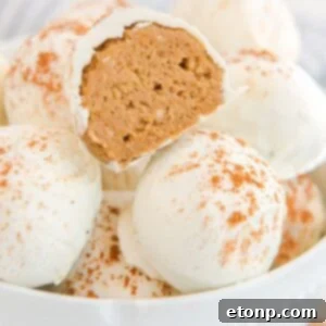 Pumpkin Spice Cheesecake Bites in a bowl with one cut in half to show filling