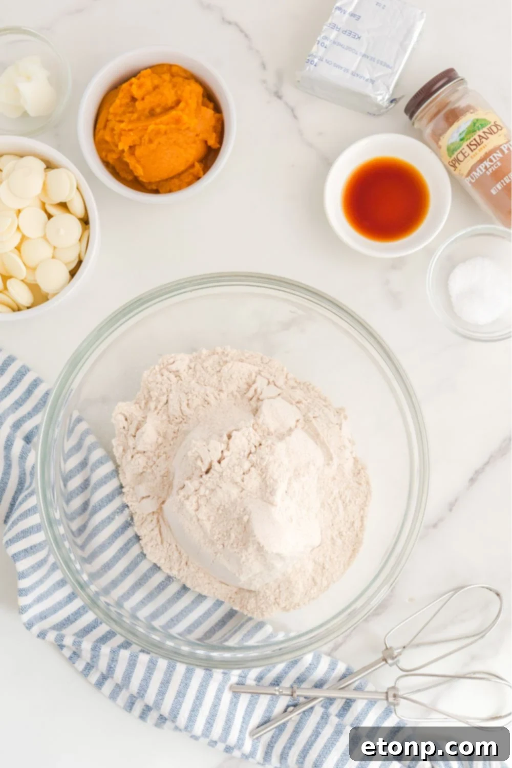Spice cake mix in a clear glass bowl on a kitchen table, ready for preparation.