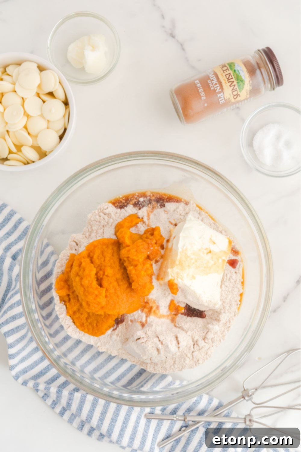 All the pumpkin cheesecake ball ingredients combined in a single glass mixing bowl, awaiting blending.