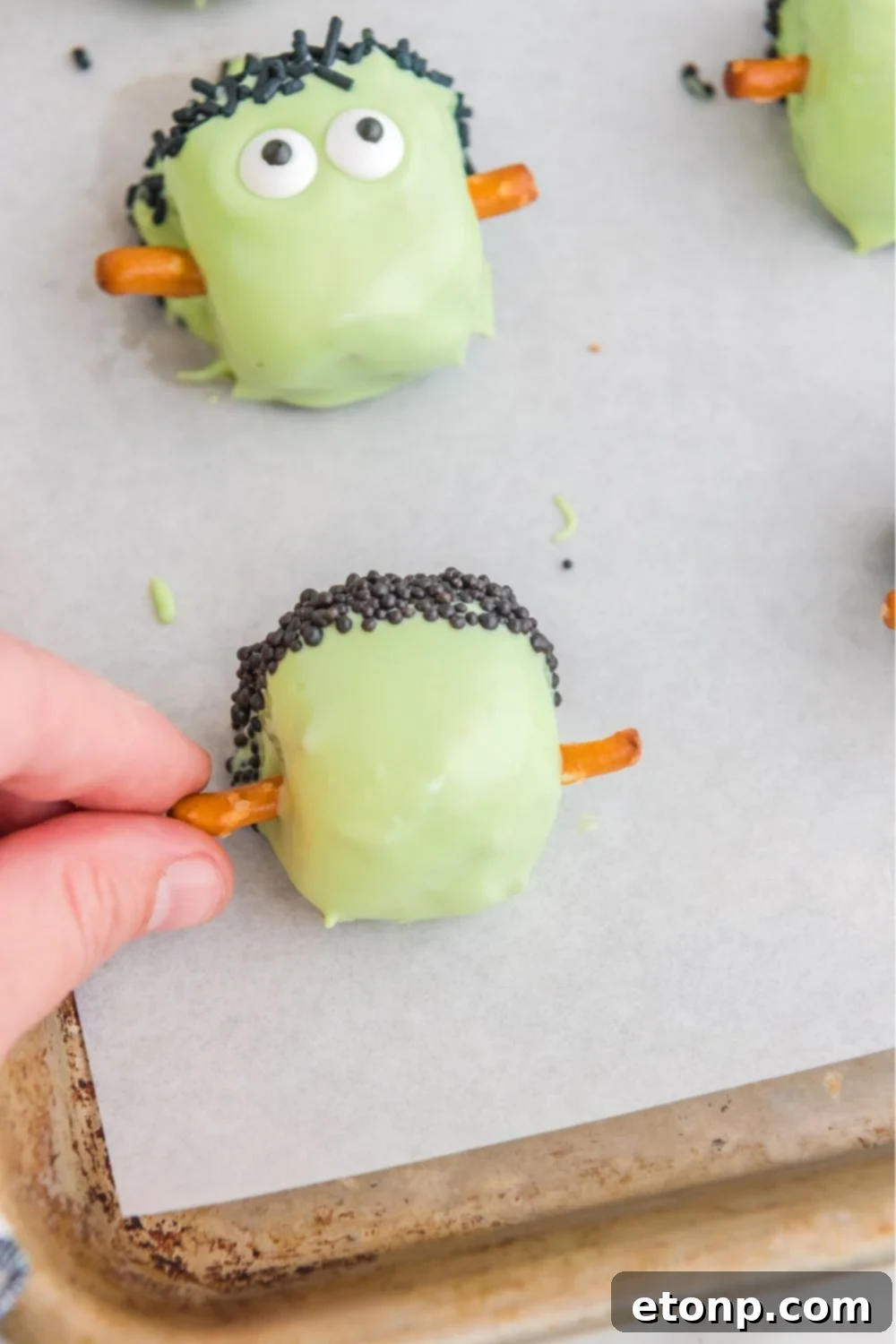 sticking pretzels into the sides of the truffles 