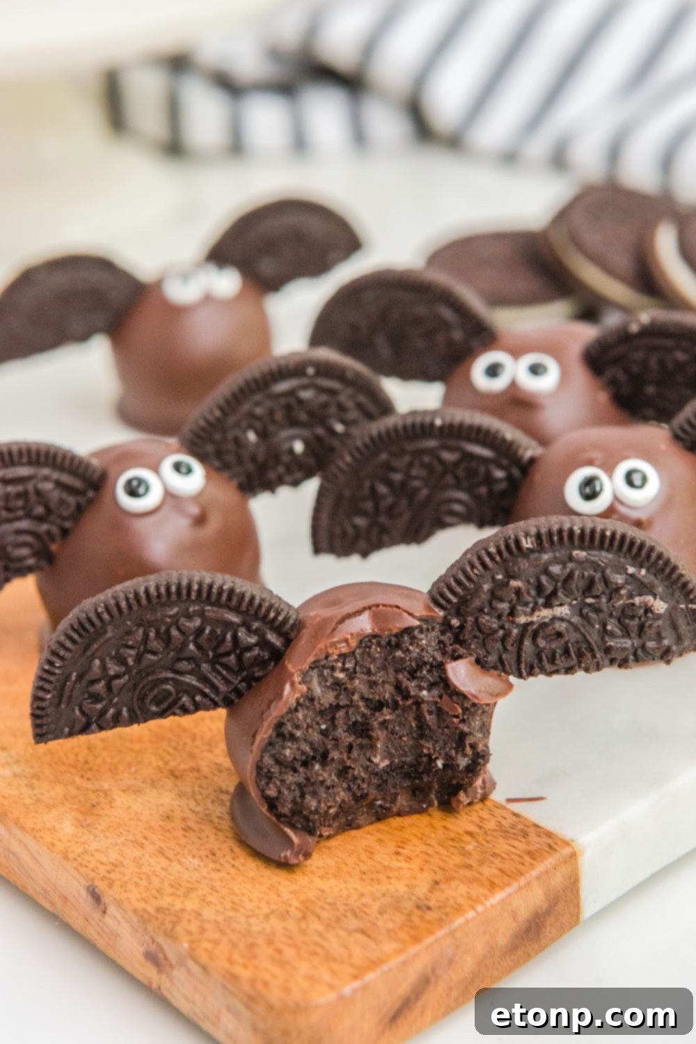 A close-up of finished Bat Oreo Truffles on a decorative serving plate