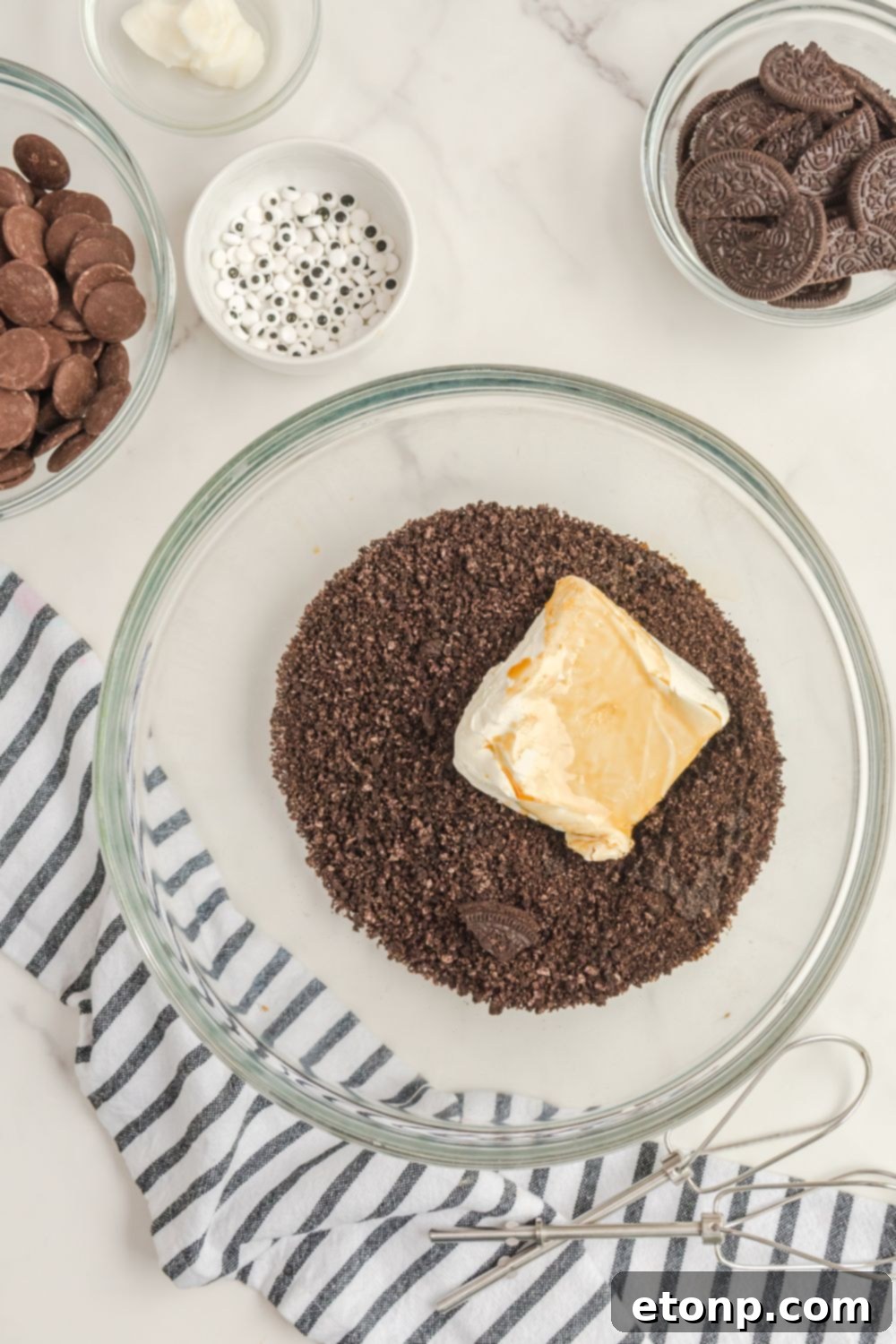 Crushed Oreo cookies and softened cream cheese in a mixing bowl, ready to be combined